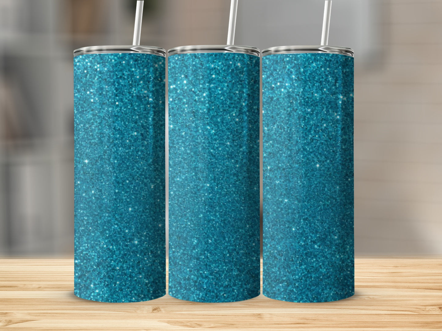 Three teal glitter tumblers with straws on a wooden surface.