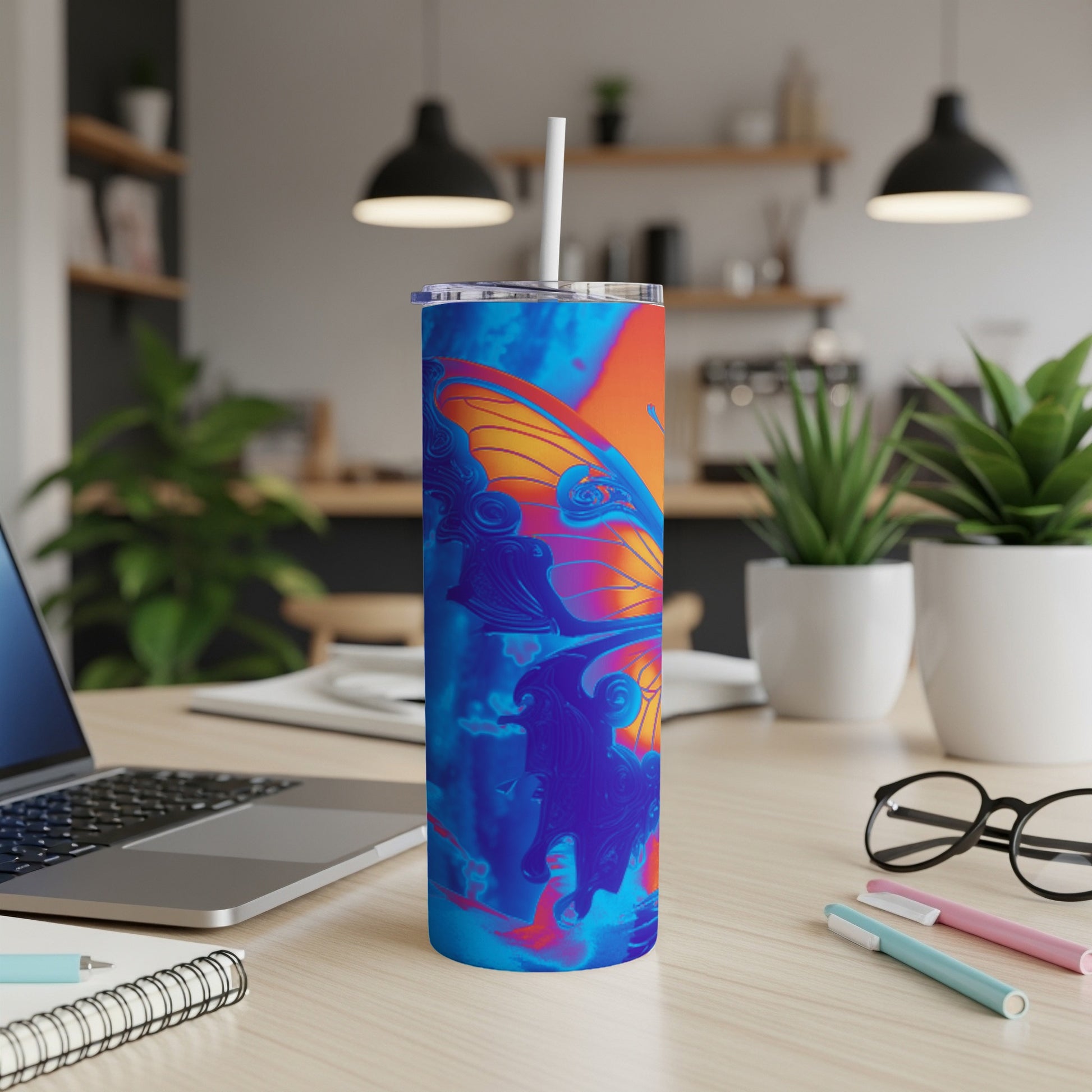 Blue and orange abstract butterfly pattern on a skinny tumbler with a straw.