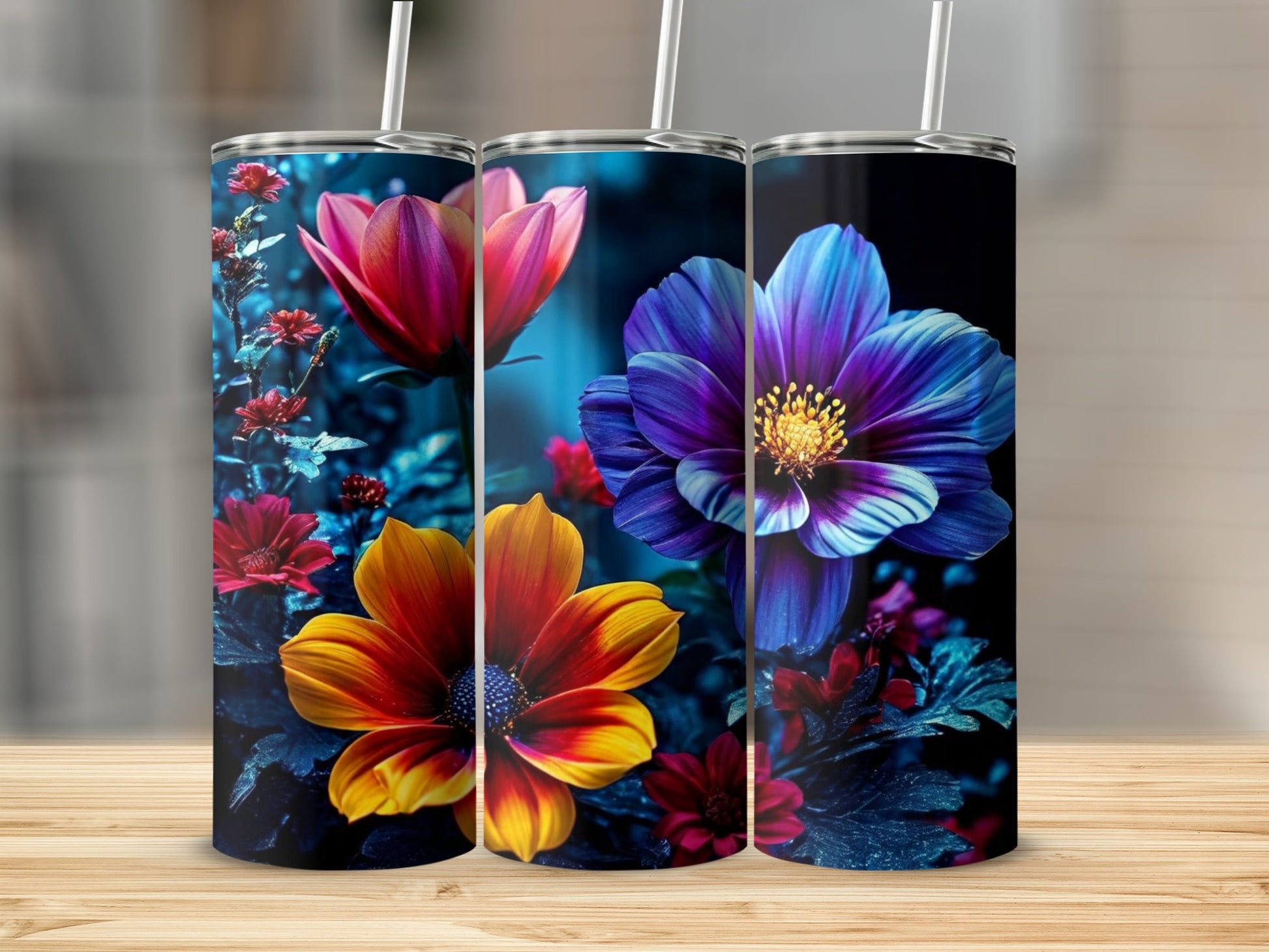 Three tumblers with vibrant floral designs of red, orange, and blue flowers.