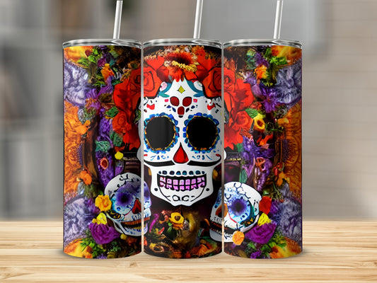 Three sugar skull tumblers with floral and skull designs on a wooden surface.