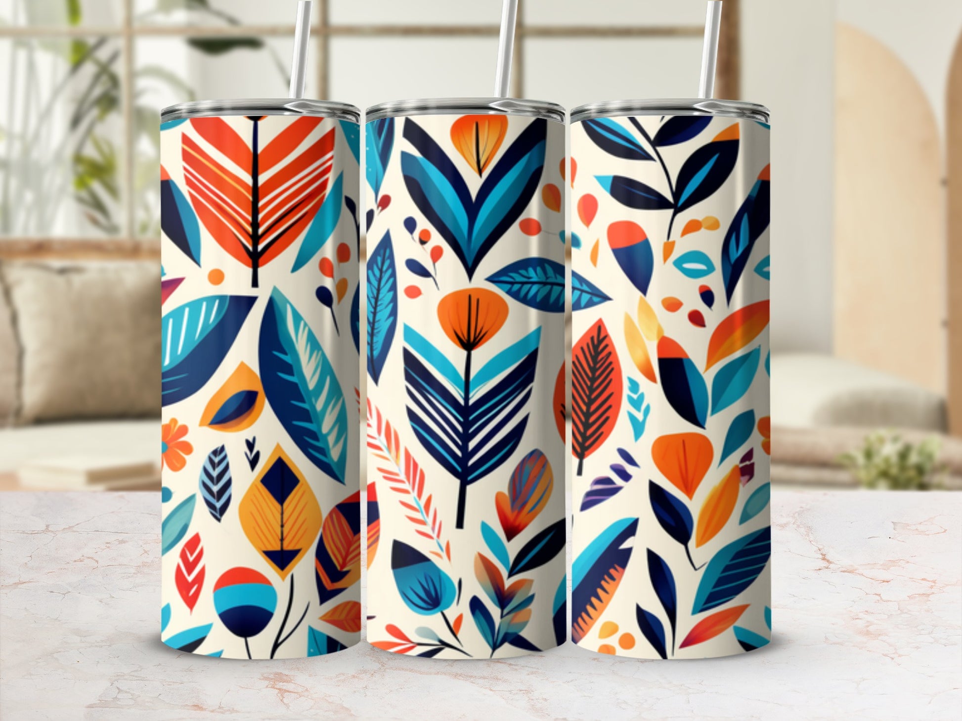 Three tumblers with a vibrant, abstract floral pattern on a light countertop.