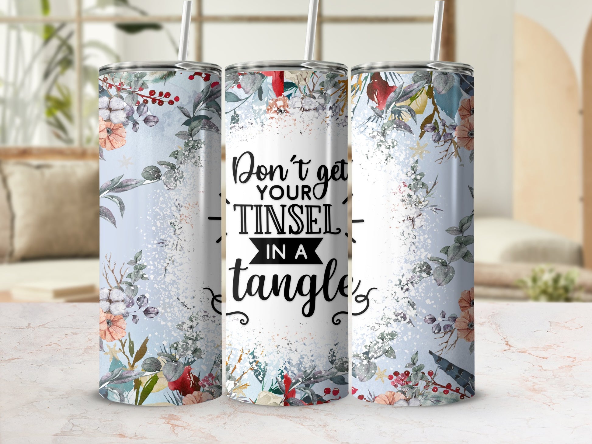 Tinsel in a tangle tumbler with floral and berry accents and a light blue background.