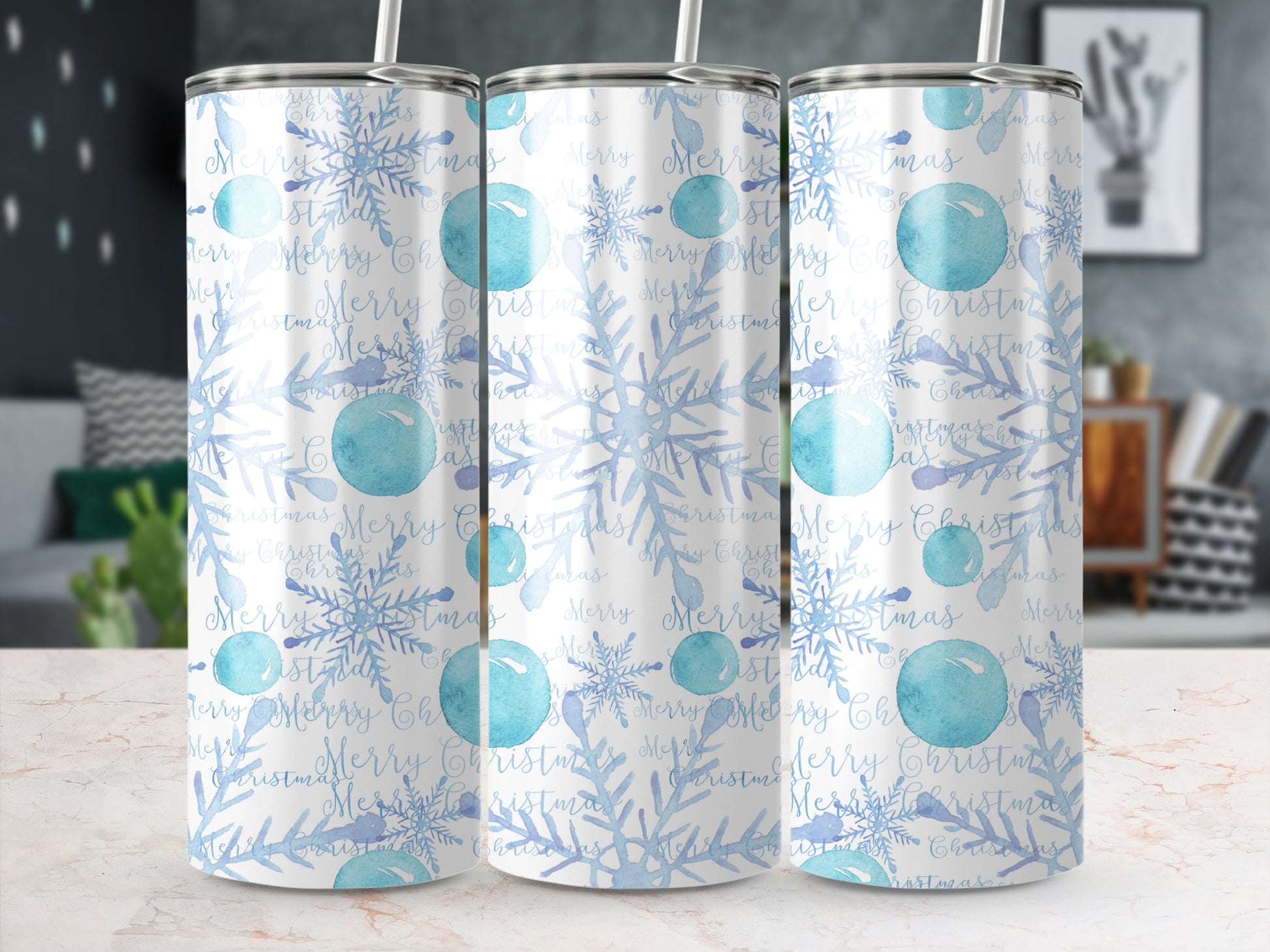 Three tumblers with a blue snowflake and "Merry Christmas" pattern on a marbled surface.