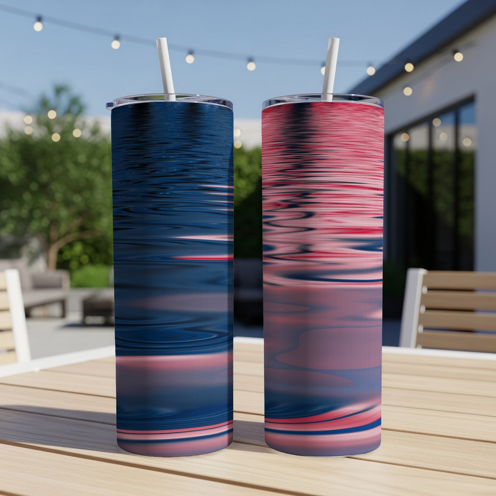 Two tall tumblers with wavy blue and red designs sit on a table.