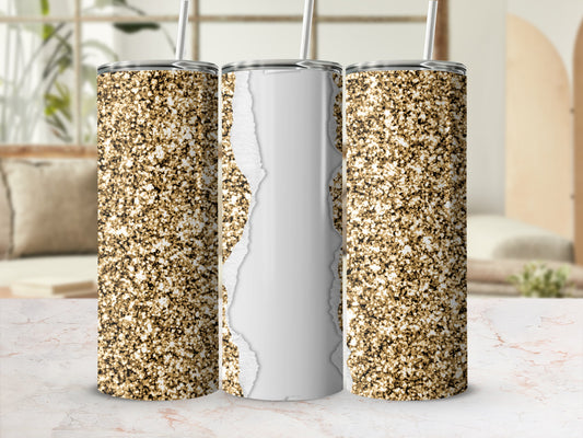 Glitter tumbler with torn paper effect and straw, on a marble surface.