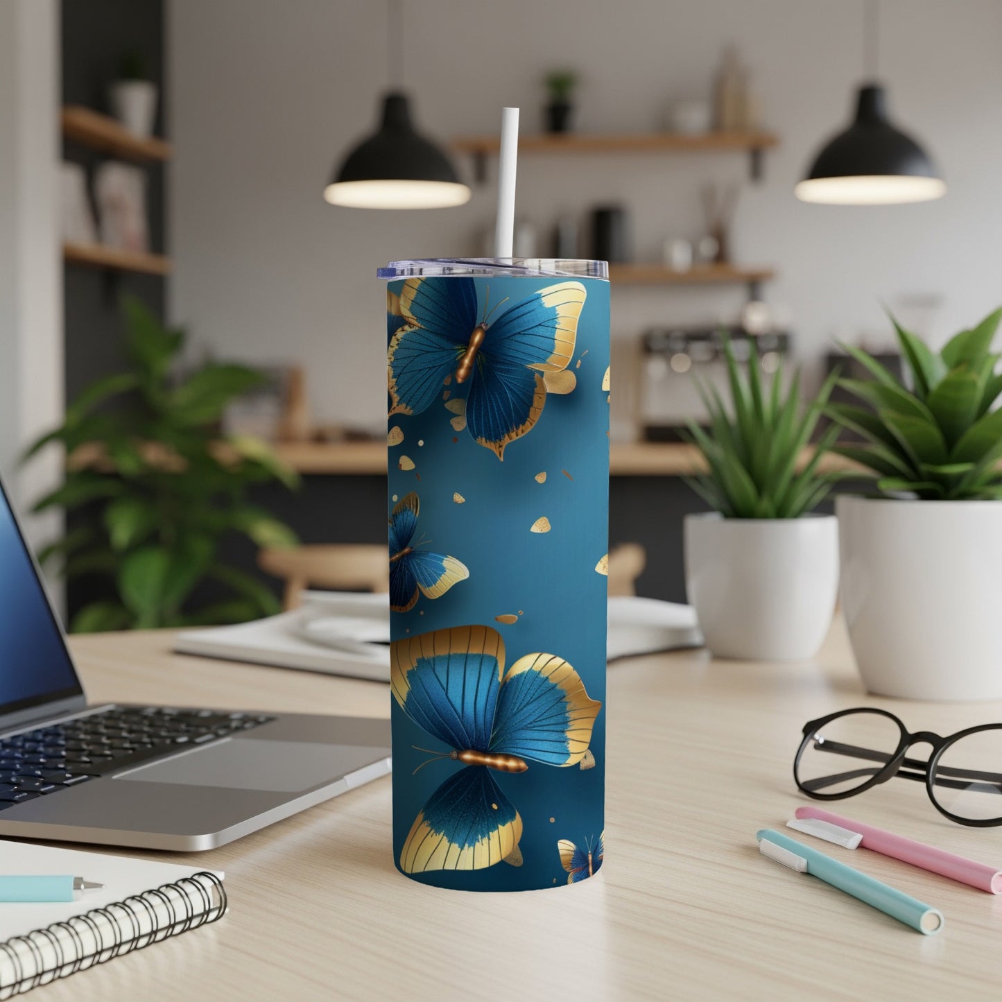 Blue and gold butterflies on a tall blue tumbler with a white straw.
