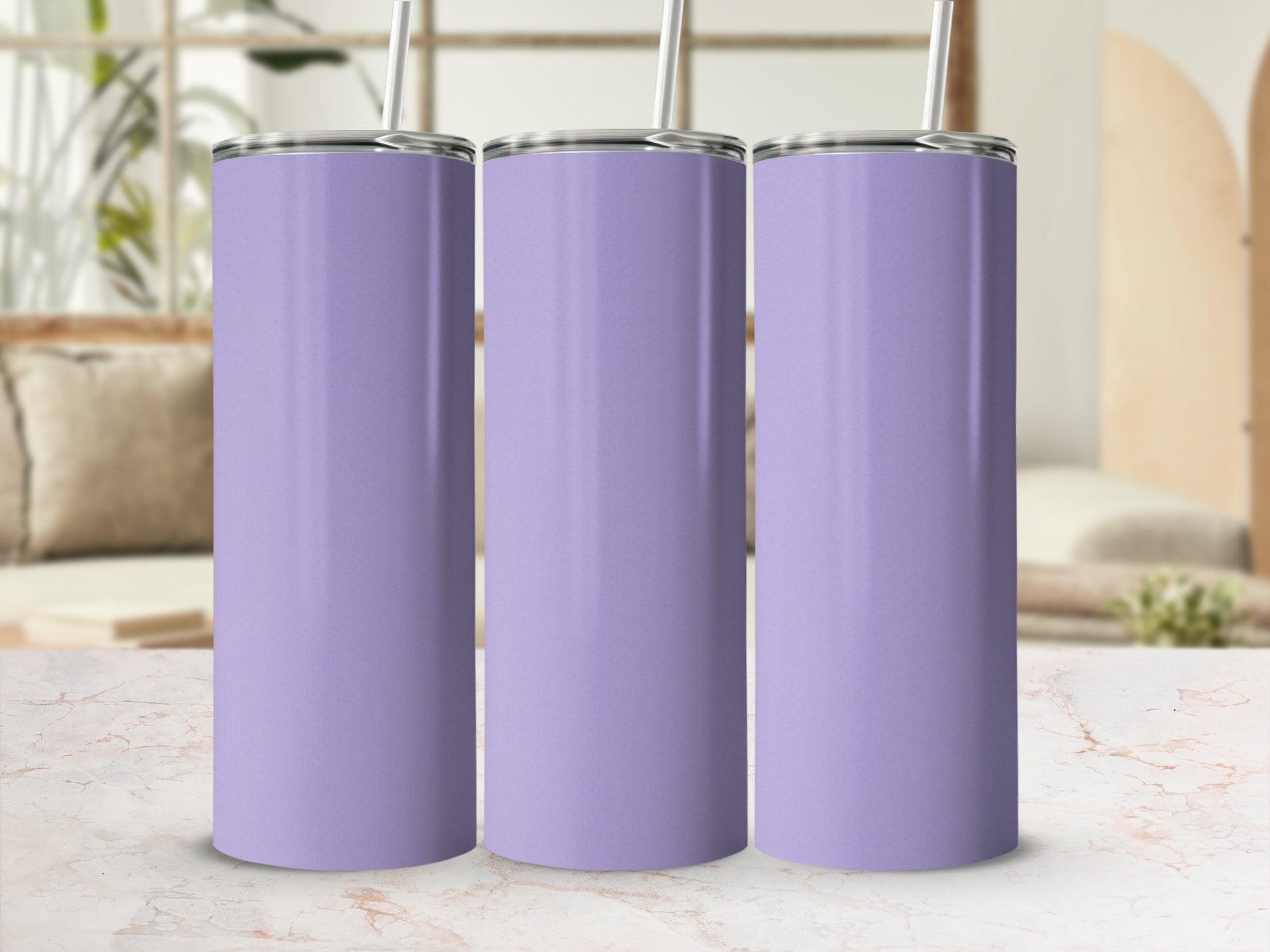 Three plain lavender tumblers with straws stand on a marble countertop.