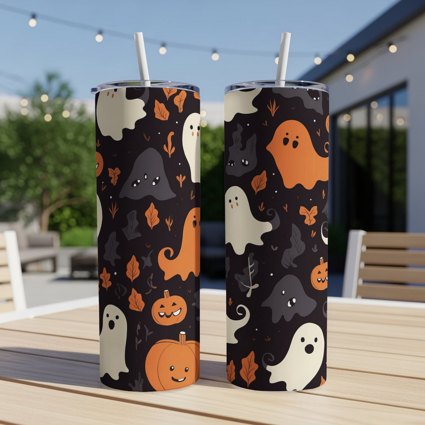 Two tumblers with Halloween ghost and pumpkin pattern, on a table outdoors.
