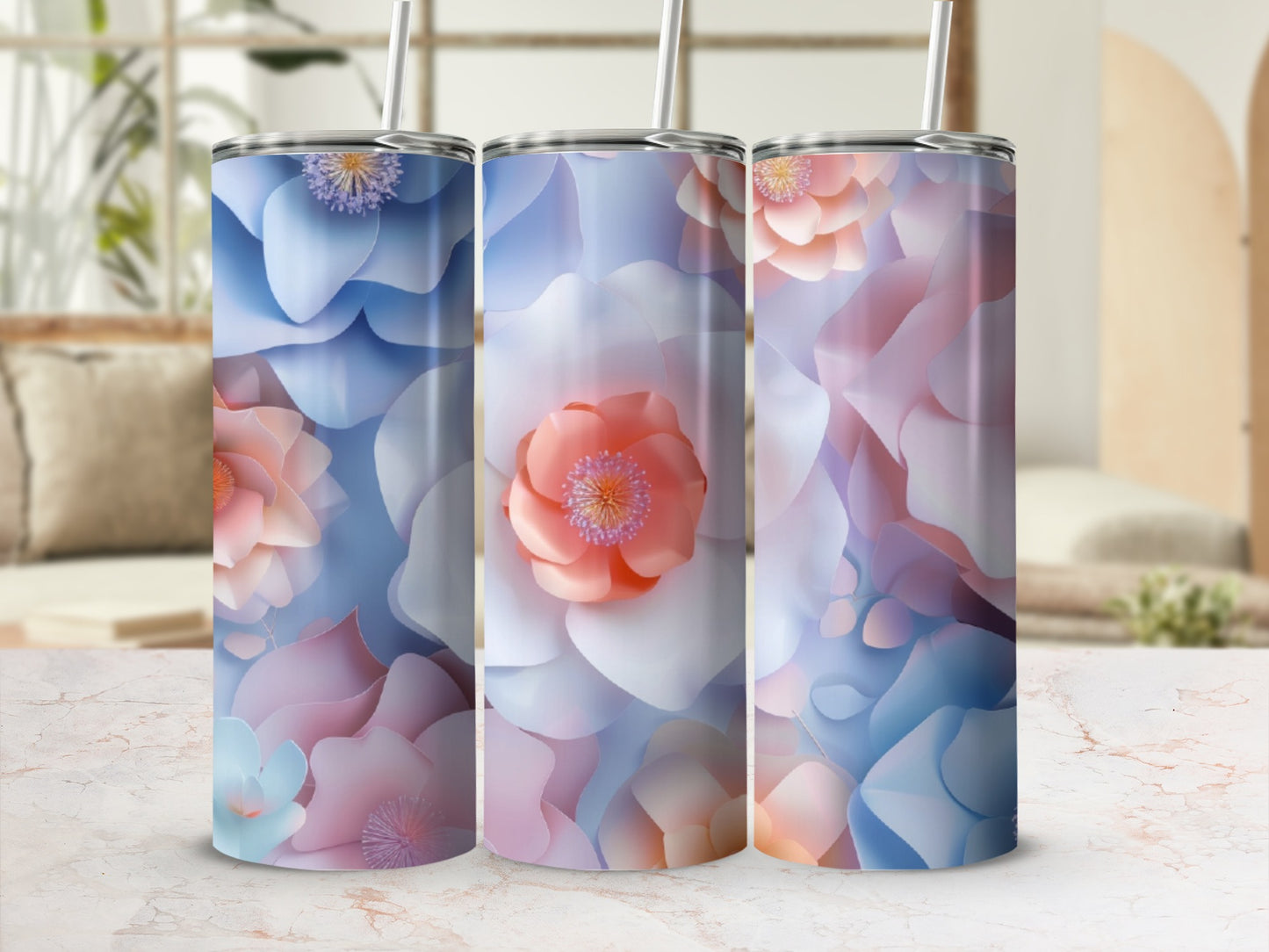 Three tall, floral-patterned tumblers with straws on a marbled surface.