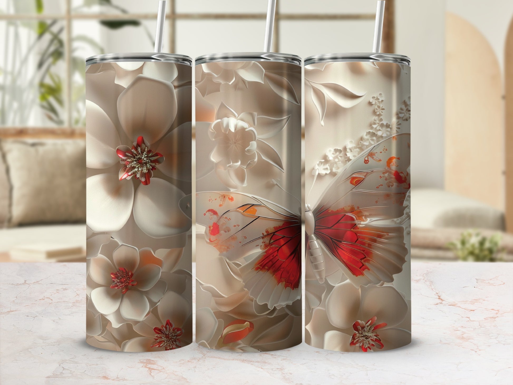 Floral and butterfly design on three tumblers with straws.