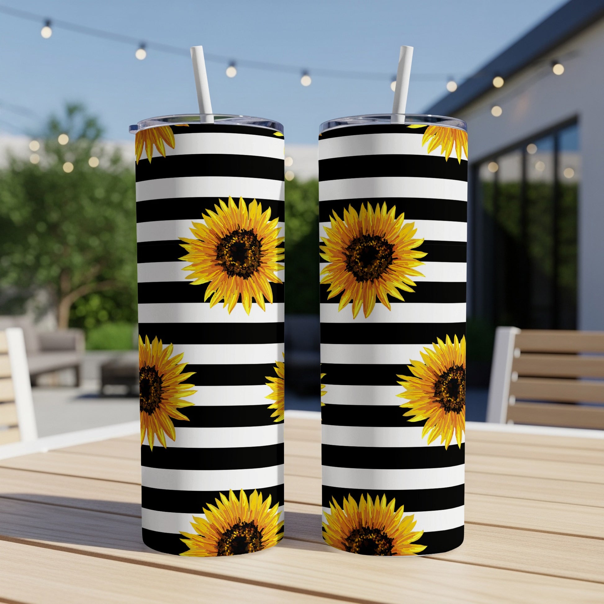 Two tumblers with black and white stripes and sunflower pattern, with straws.