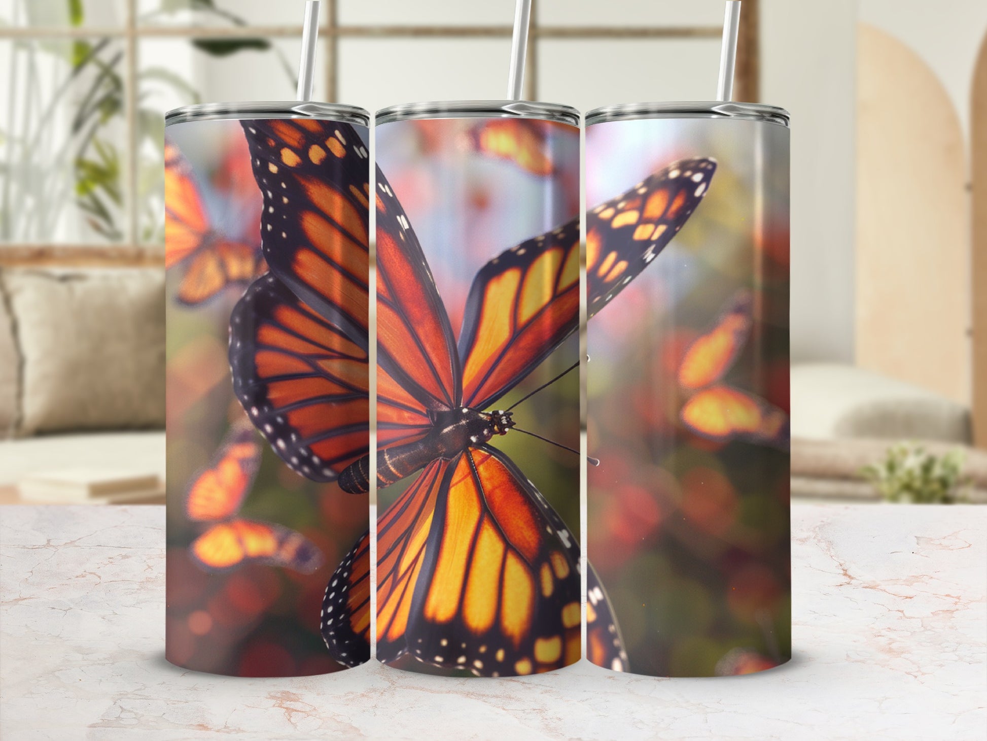 Three tumblers featuring monarch butterflies against a blurred background.