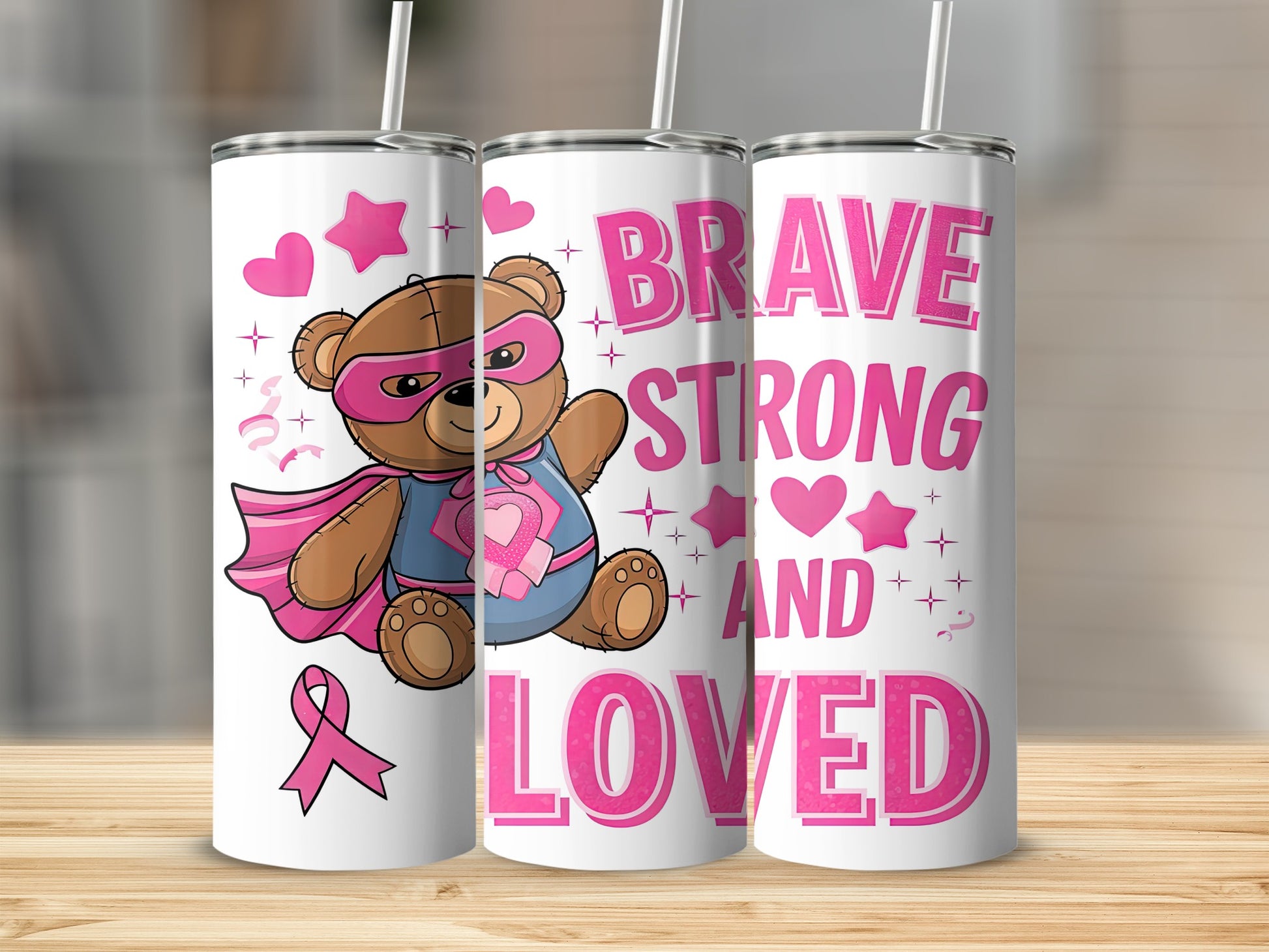 Super teddy bear in superhero costume with pink ribbon and "Brave Strong and Loved" text.
