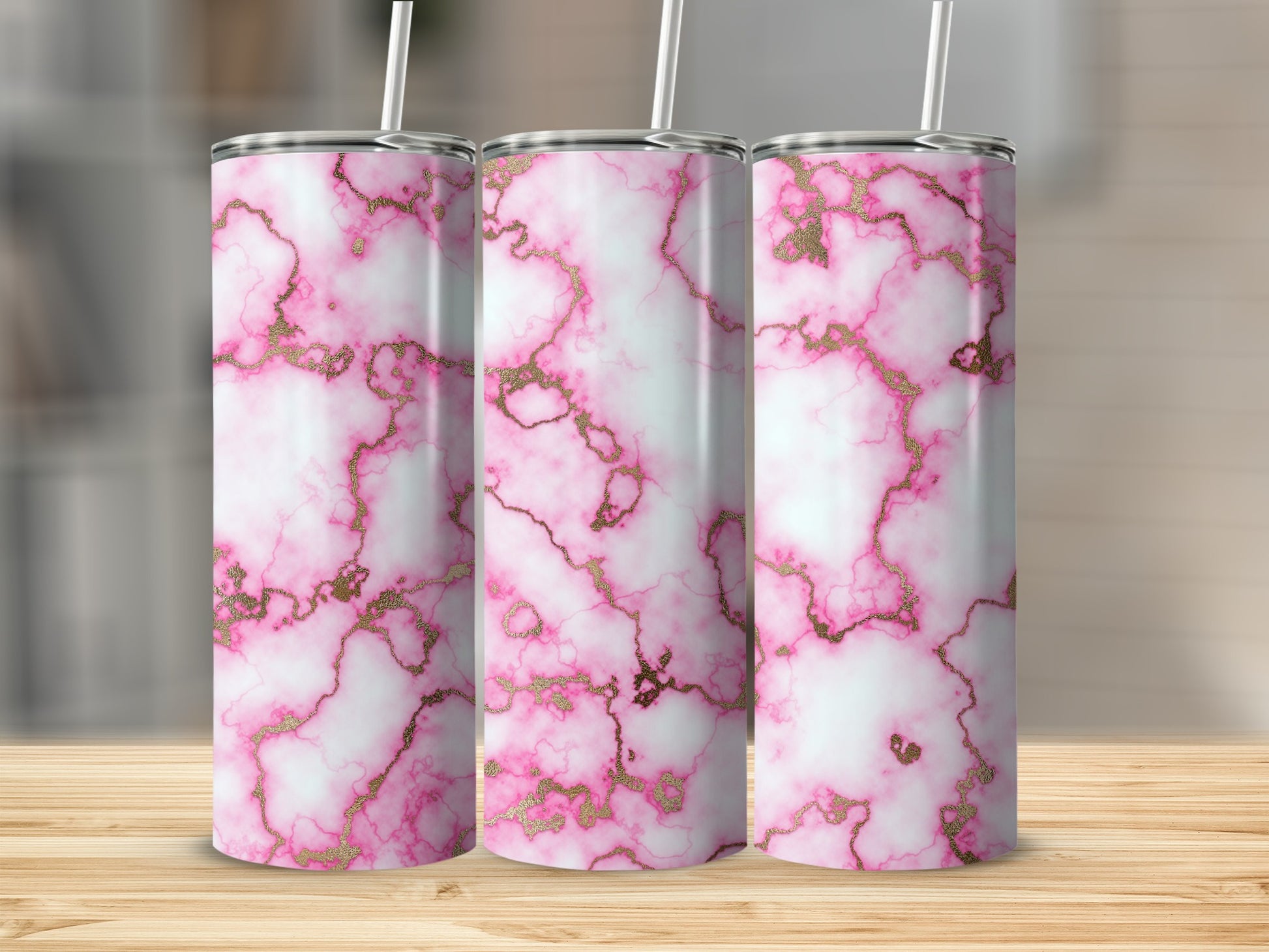 Three pink marble tumblers with gold veining and white straws.
