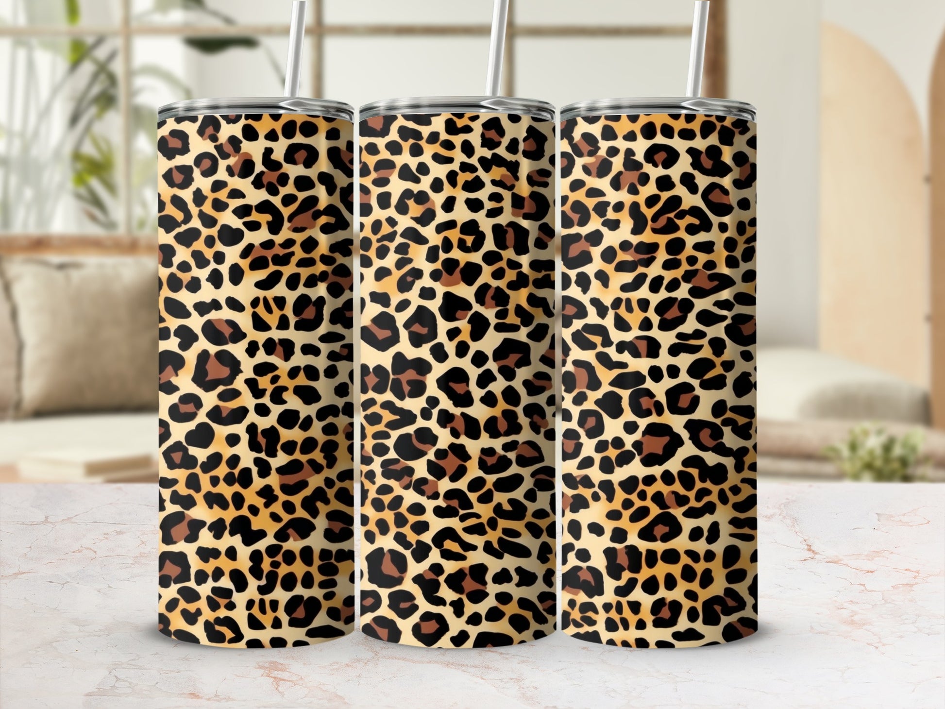 Three tumblers with a leopard print design and metal straws.