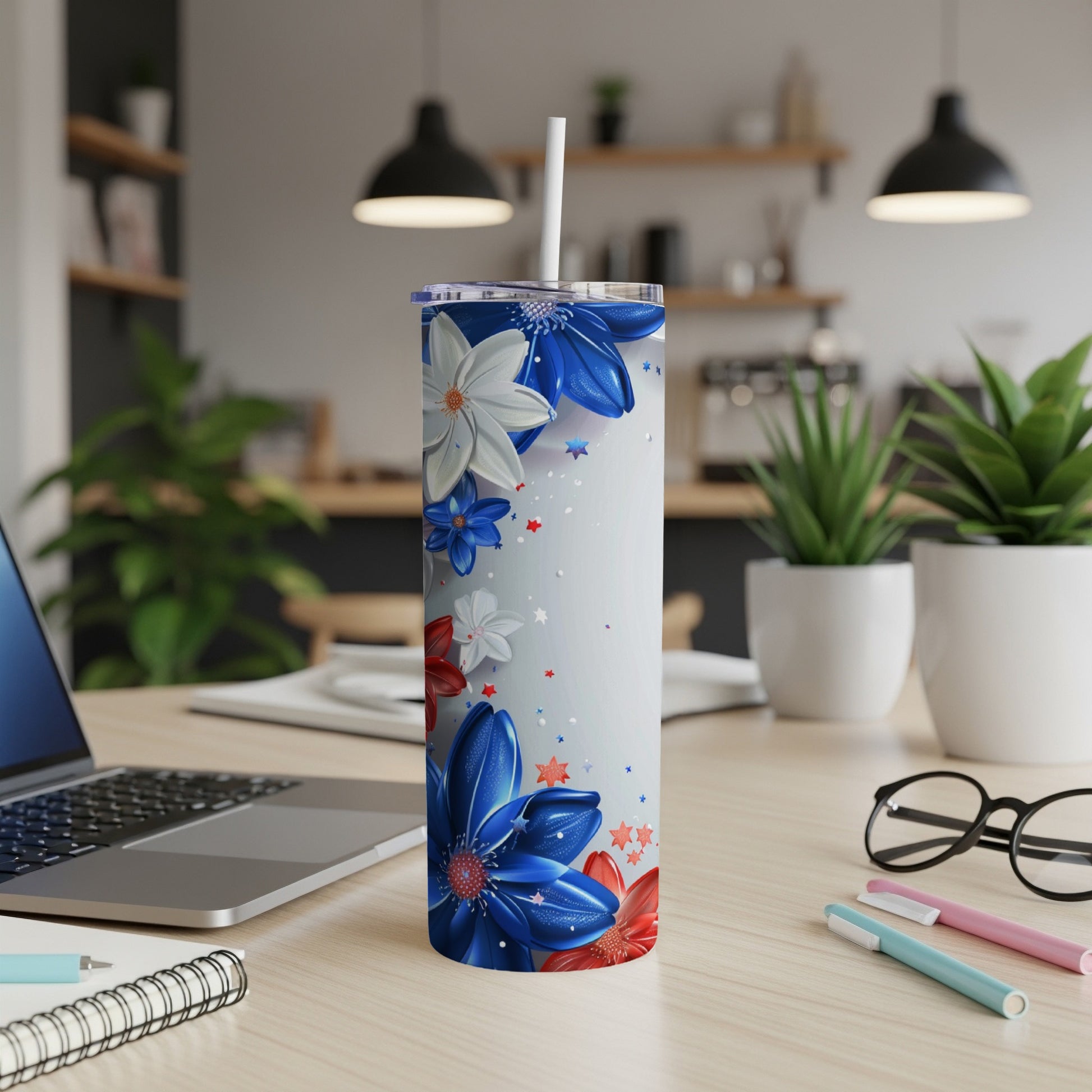 White tumbler with red, white, and blue floral design on a desk.