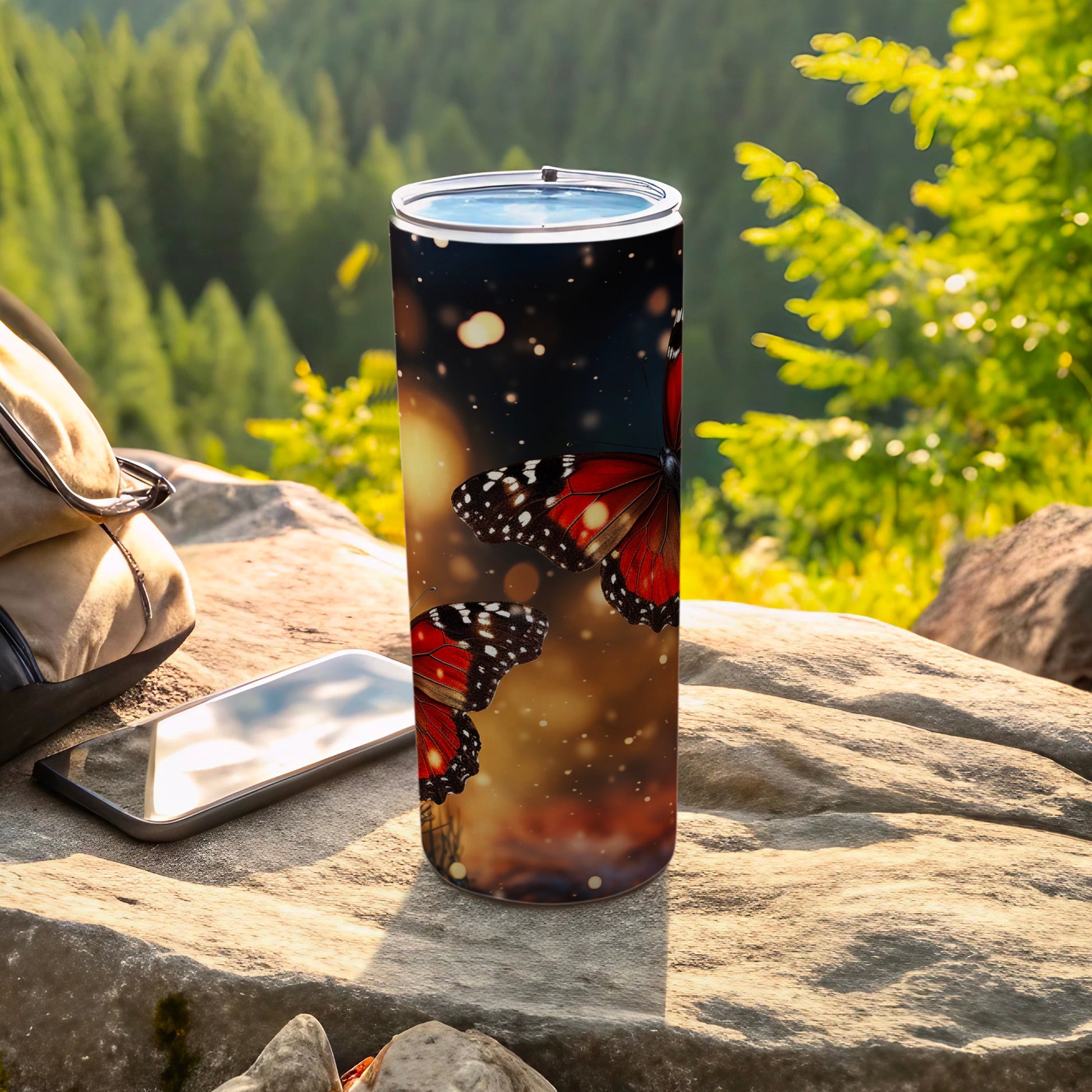 Tumbler with vibrant red and black butterflies against a blurred forest background.