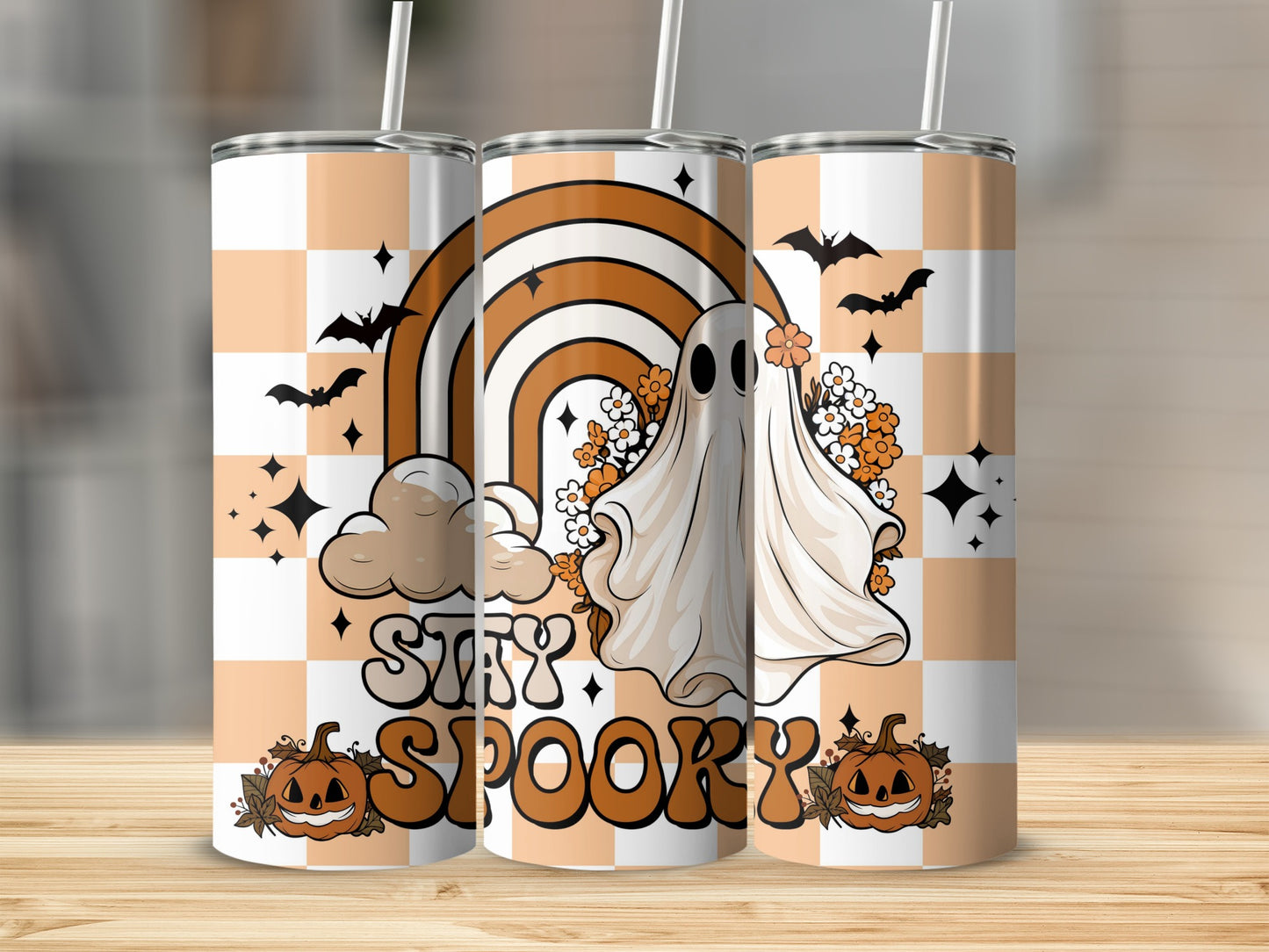 "Stay Spooky" tumbler with ghost, rainbow, bats, and pumpkins on checkerboard pattern.