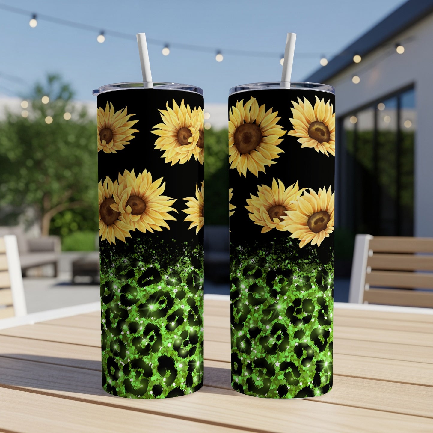 Two tumblers with sunflowers and green leopard print on a table outdoors.