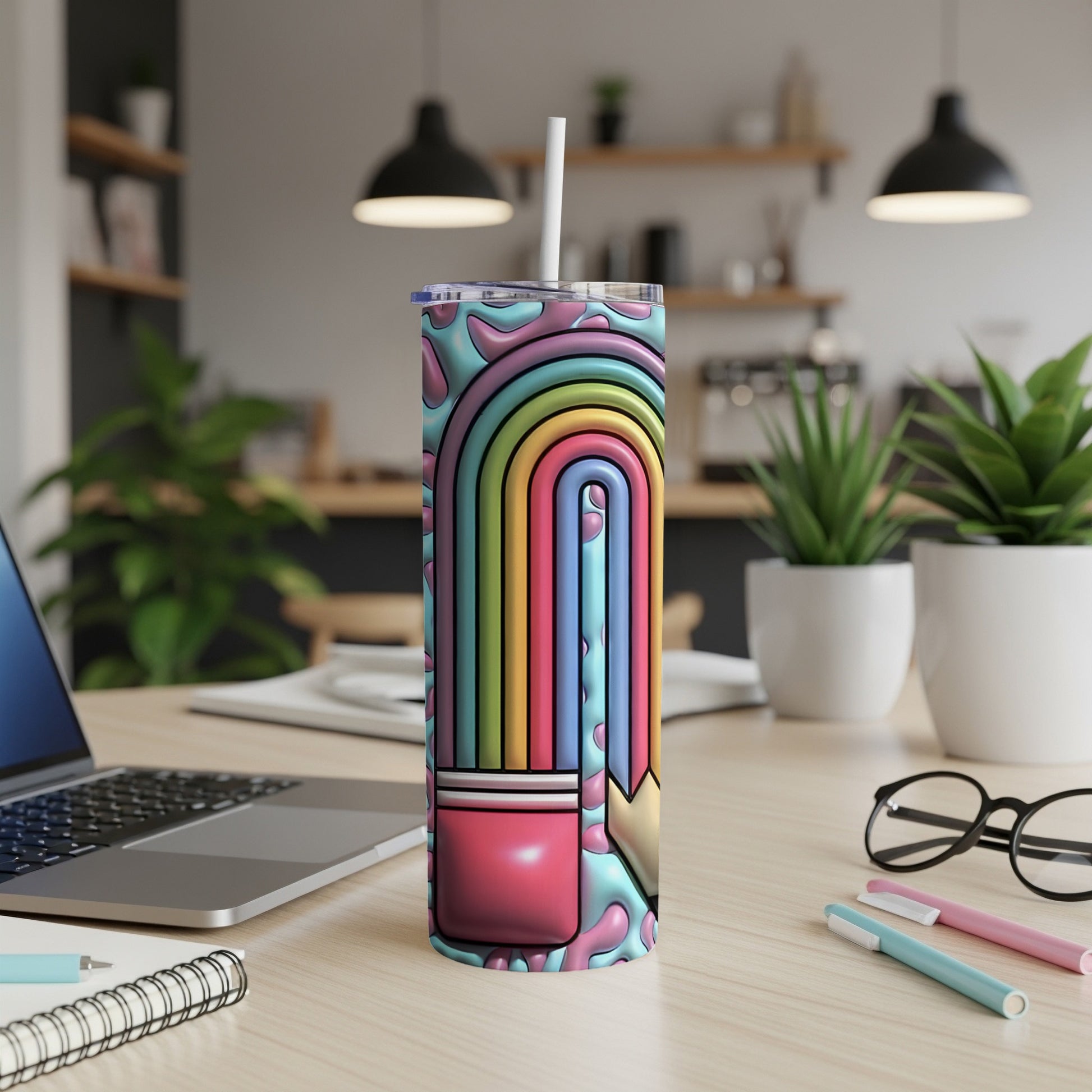 Colorful rainbow design on a white tumbler with a straw, on a desk.
