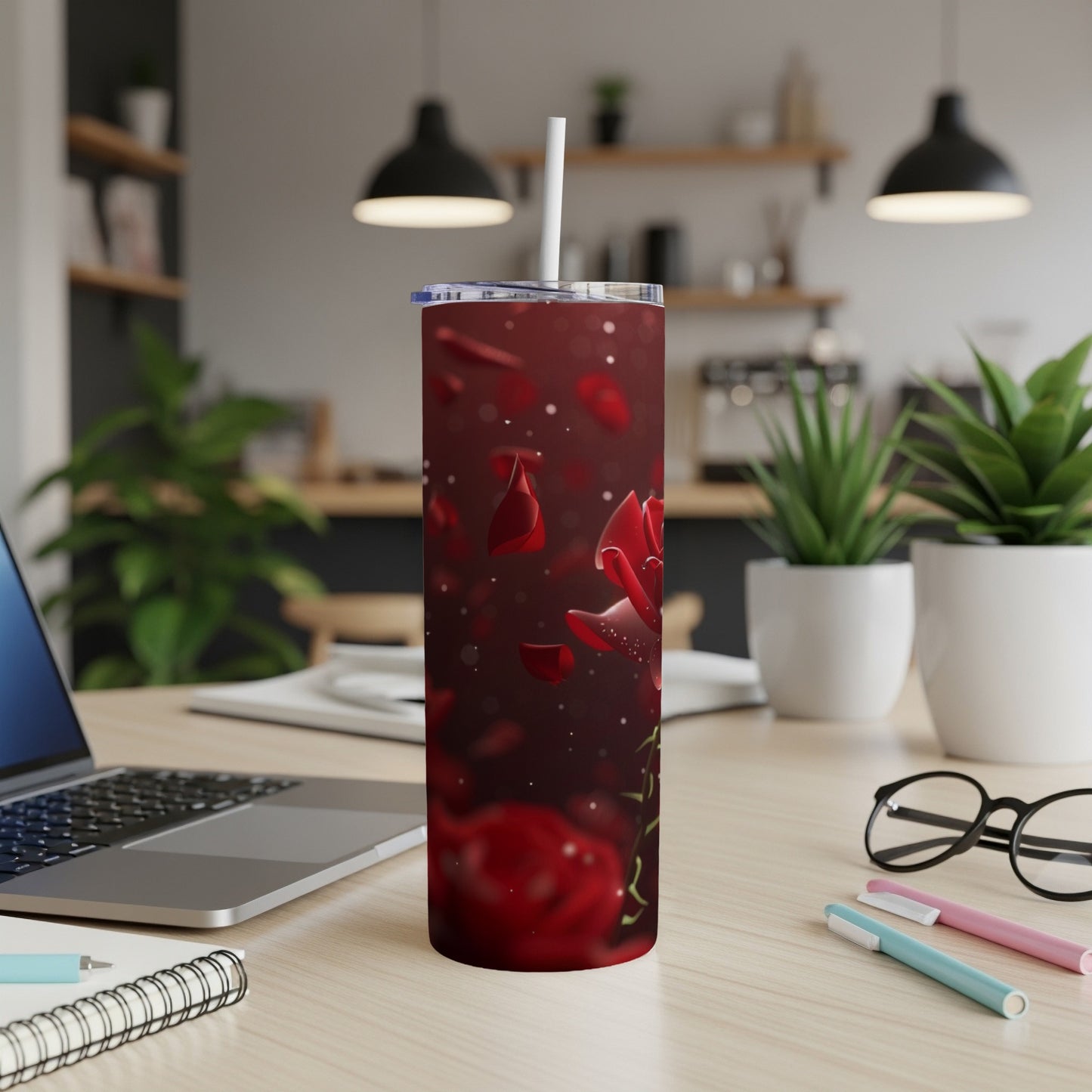 Red rose petals falling on a tumbler with a white straw.