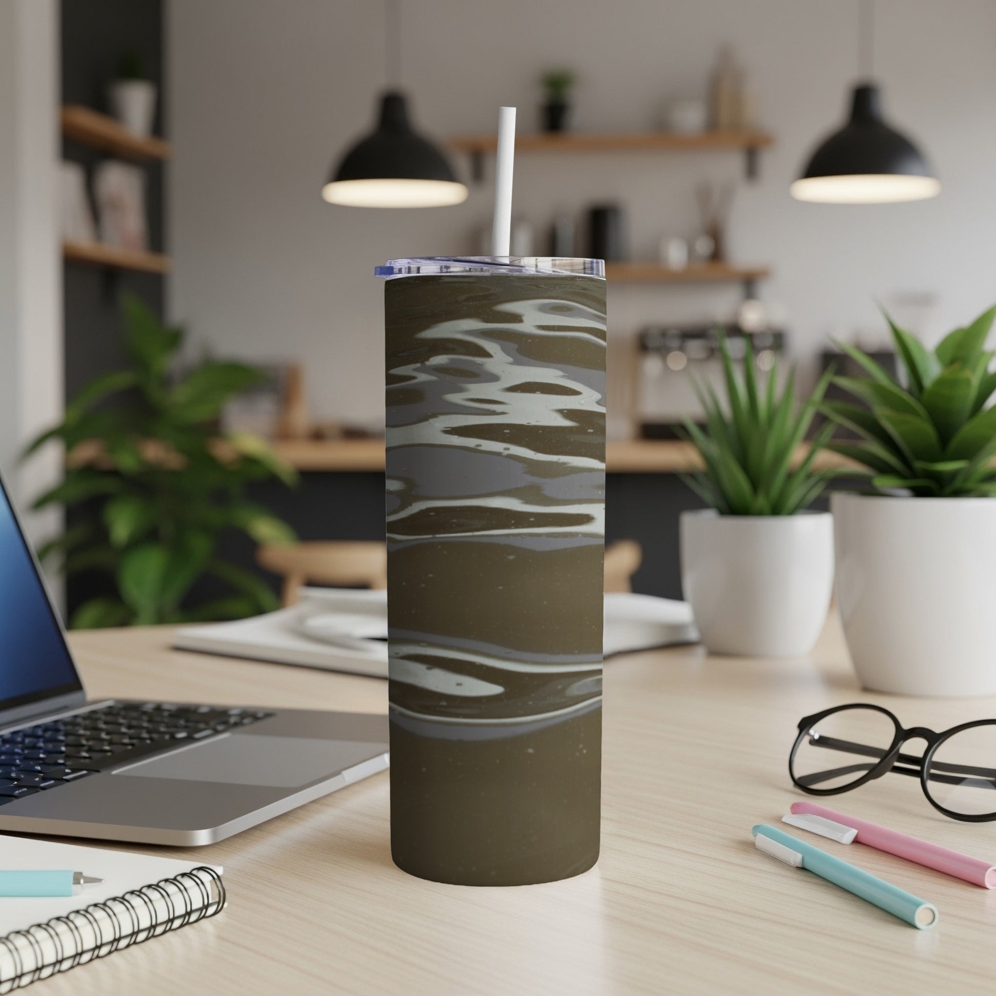 Dark brown tumbler with wavy gray and white pattern, on a desk.