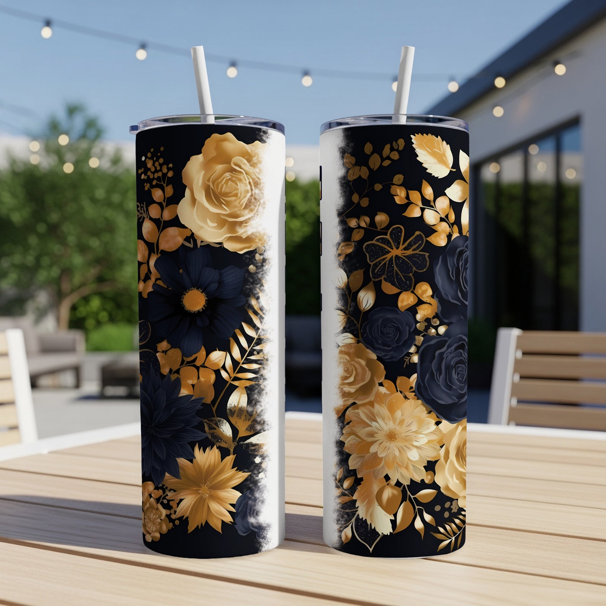 Two gold and black floral tumblers with straws on a wooden table.