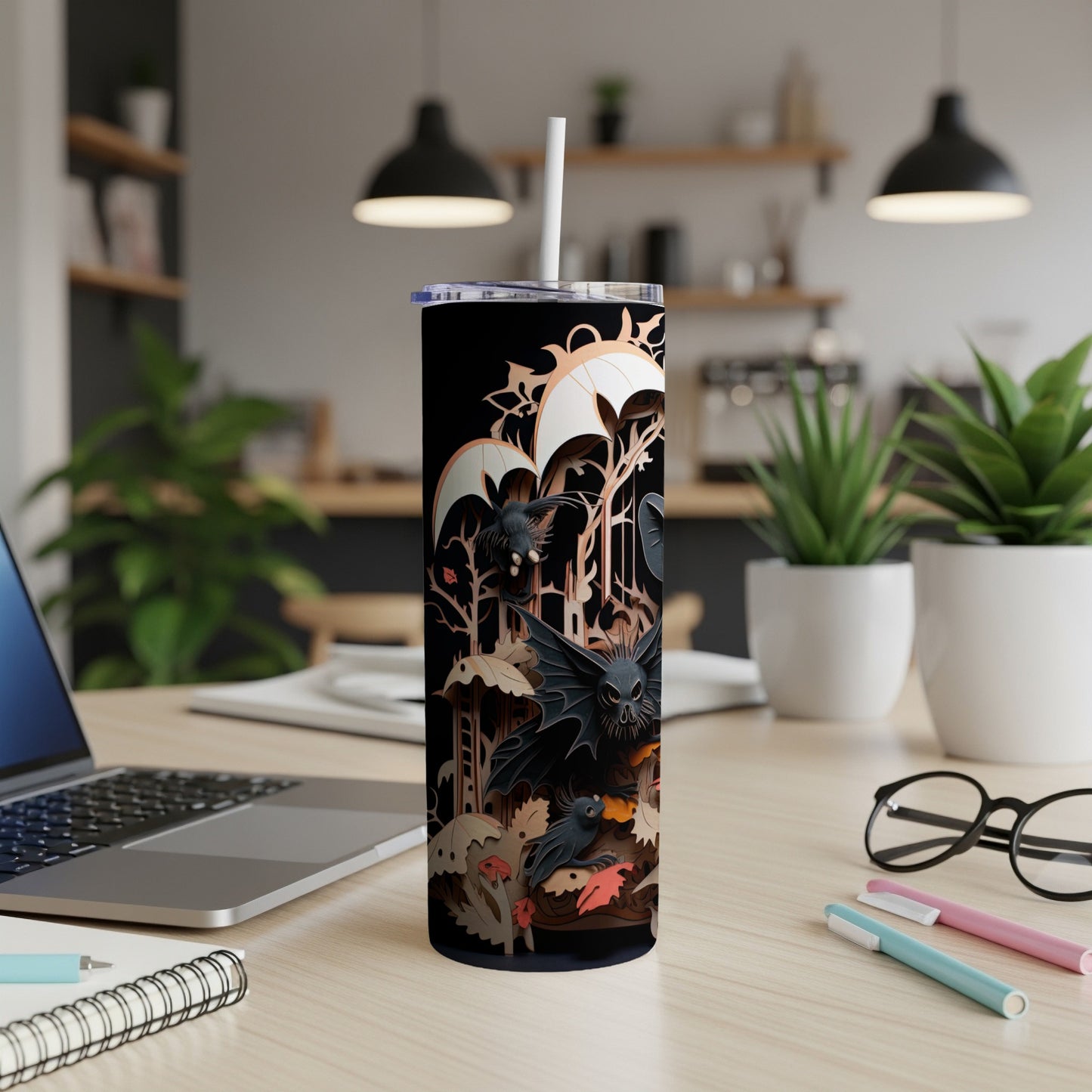 Black tumbler with cutout bats, trees, and umbrellas in a spooky forest scene.
