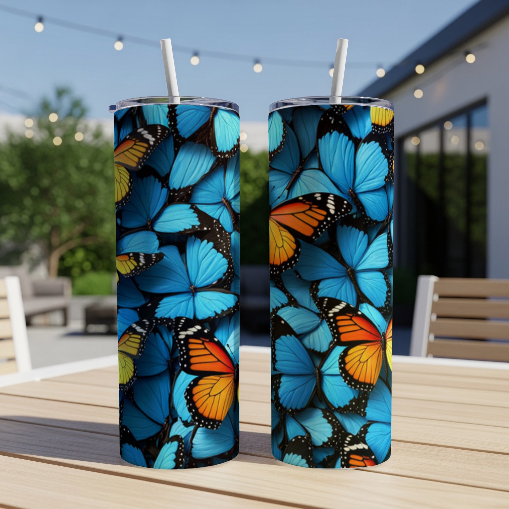 Two blue and orange butterfly patterned tumblers on a table.