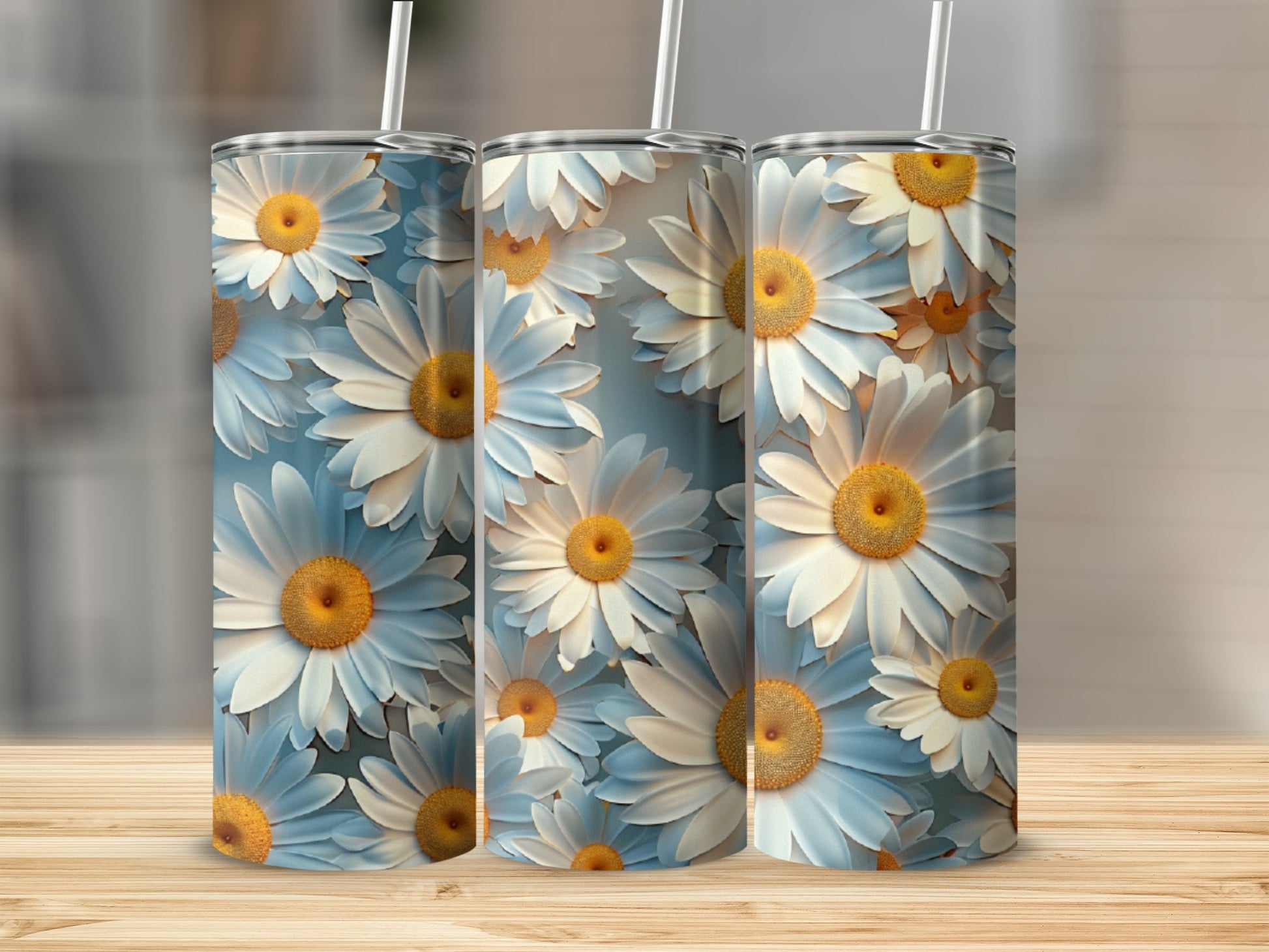 Three tumblers with a white and yellow daisy floral pattern on a wooden surface.