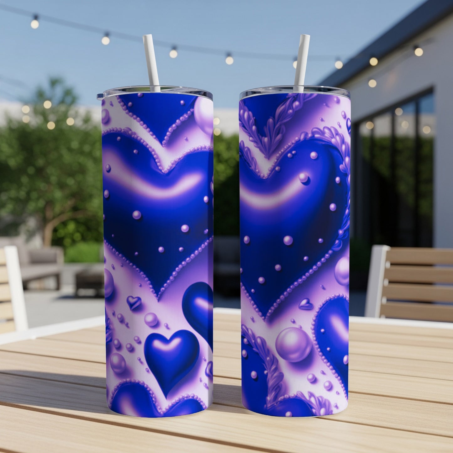 Blue hearts pattern on two tumblers with straws on a wooden table.