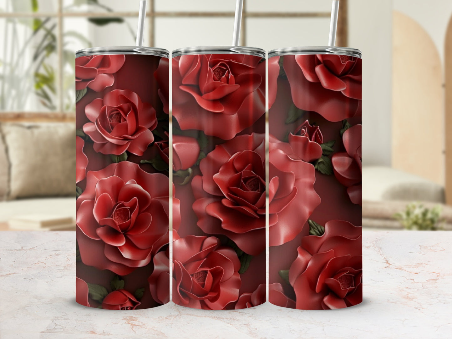 Three red rose tumblers with straws on a marble countertop.
