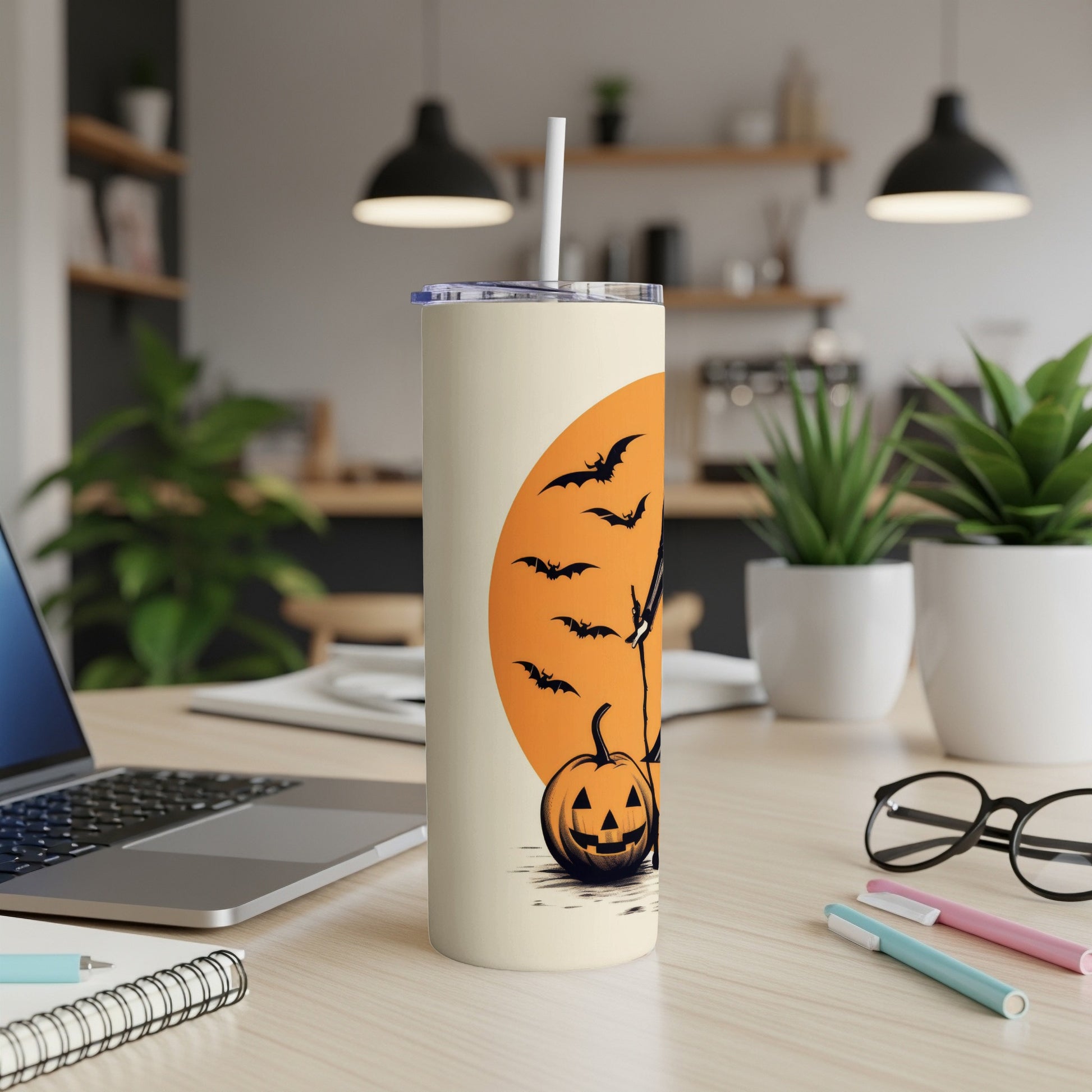 Tall tumbler with Halloween design of pumpkin, bats, and a tree against an orange moon.