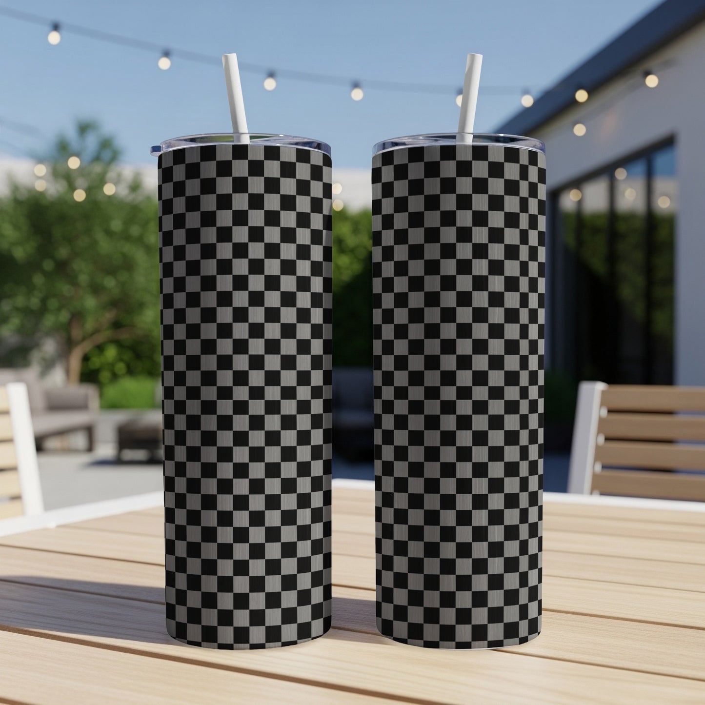 Two tall tumblers with black and white checkered patterns on a wooden table.