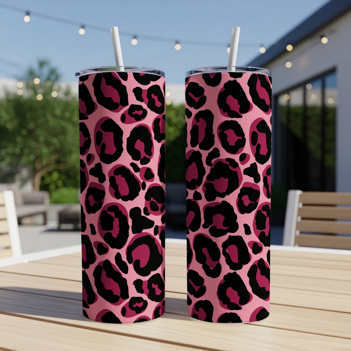 Two pink tumblers with black and deep pink leopard print and white straws.