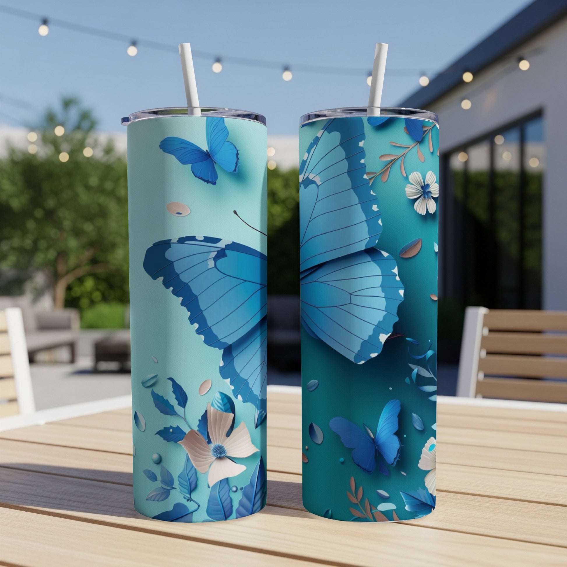 Two blue butterfly tumblers with floral accents on a wooden table.