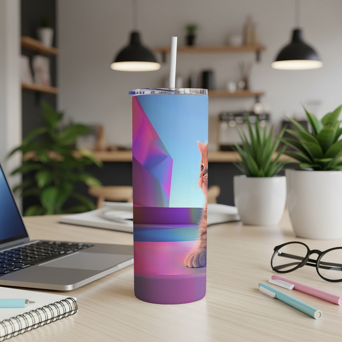 Orange tabby kitten peeking over geometric shapes on a blue and purple tumbler.