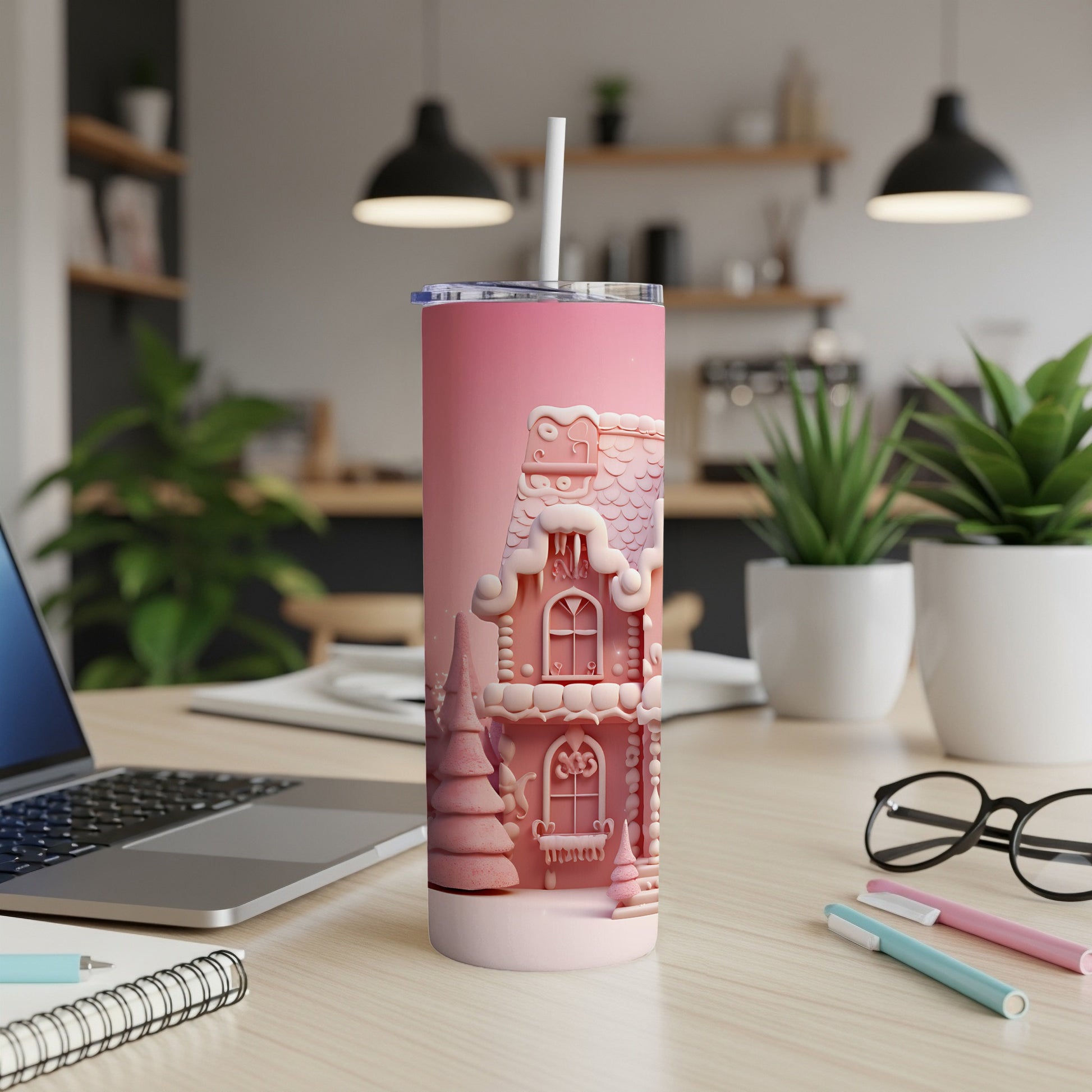 Pink gingerbread house tumbler with straw on desk.