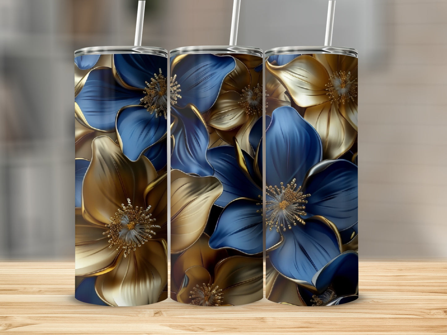 Three tumblers with blue and gold floral designs stand on a wooden surface.