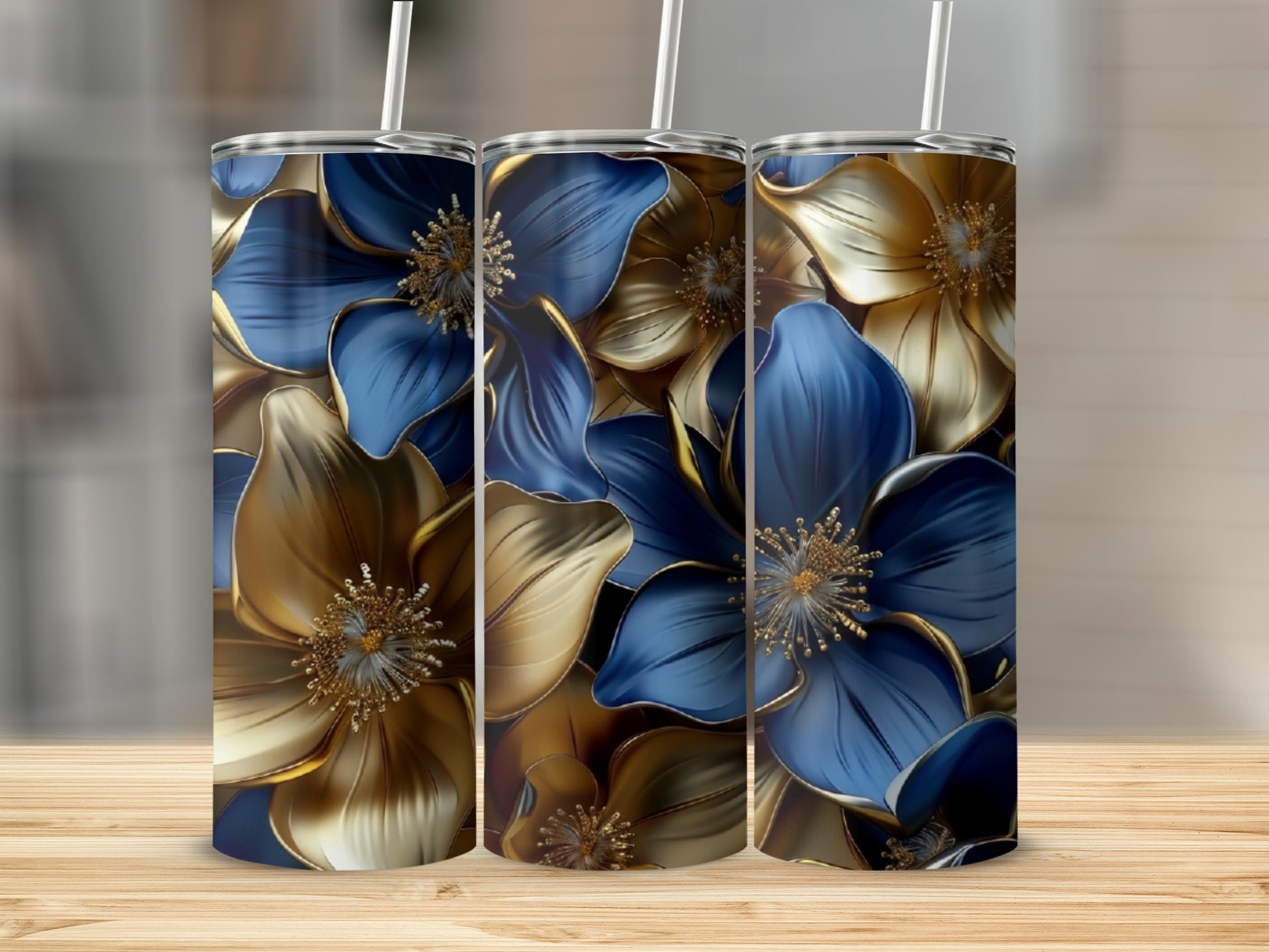 Three tumblers with blue and gold floral designs stand on a wooden surface.
