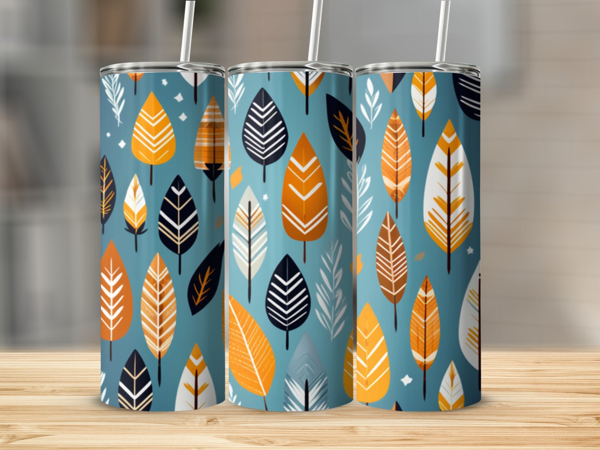 Three tumblers with a pattern of stylized leaves in orange, white, and black.