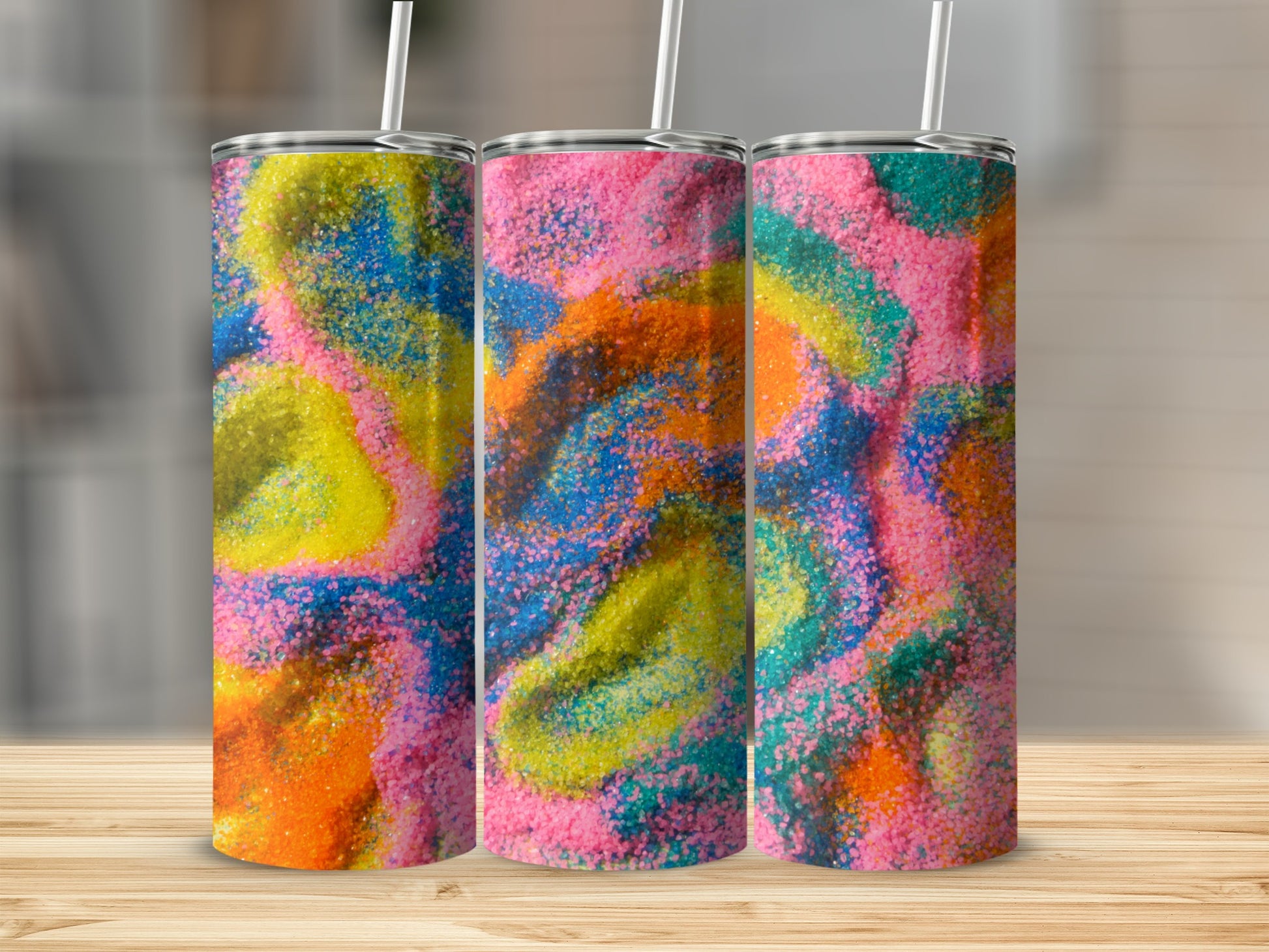 Three tumblers with swirling patterns of colorful sand.