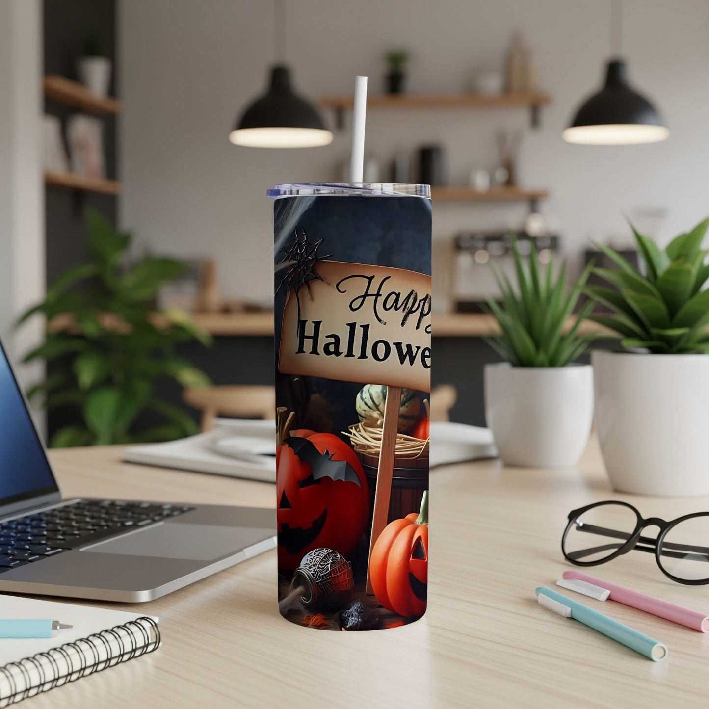 Tumbler with Halloween pumpkins and a "Happy Halloween" sign in a modern desk setting.