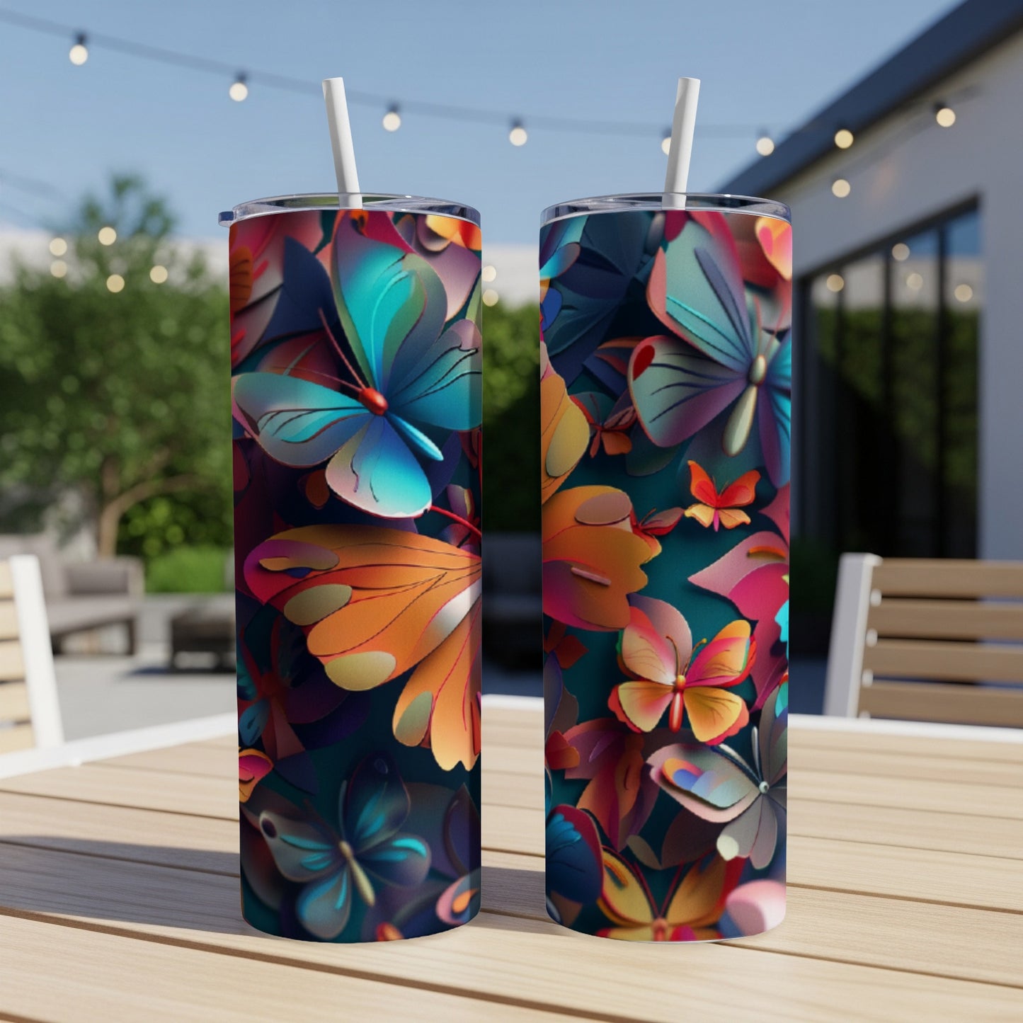 Two colorful butterfly-patterned tumblers on a wooden table outdoors.