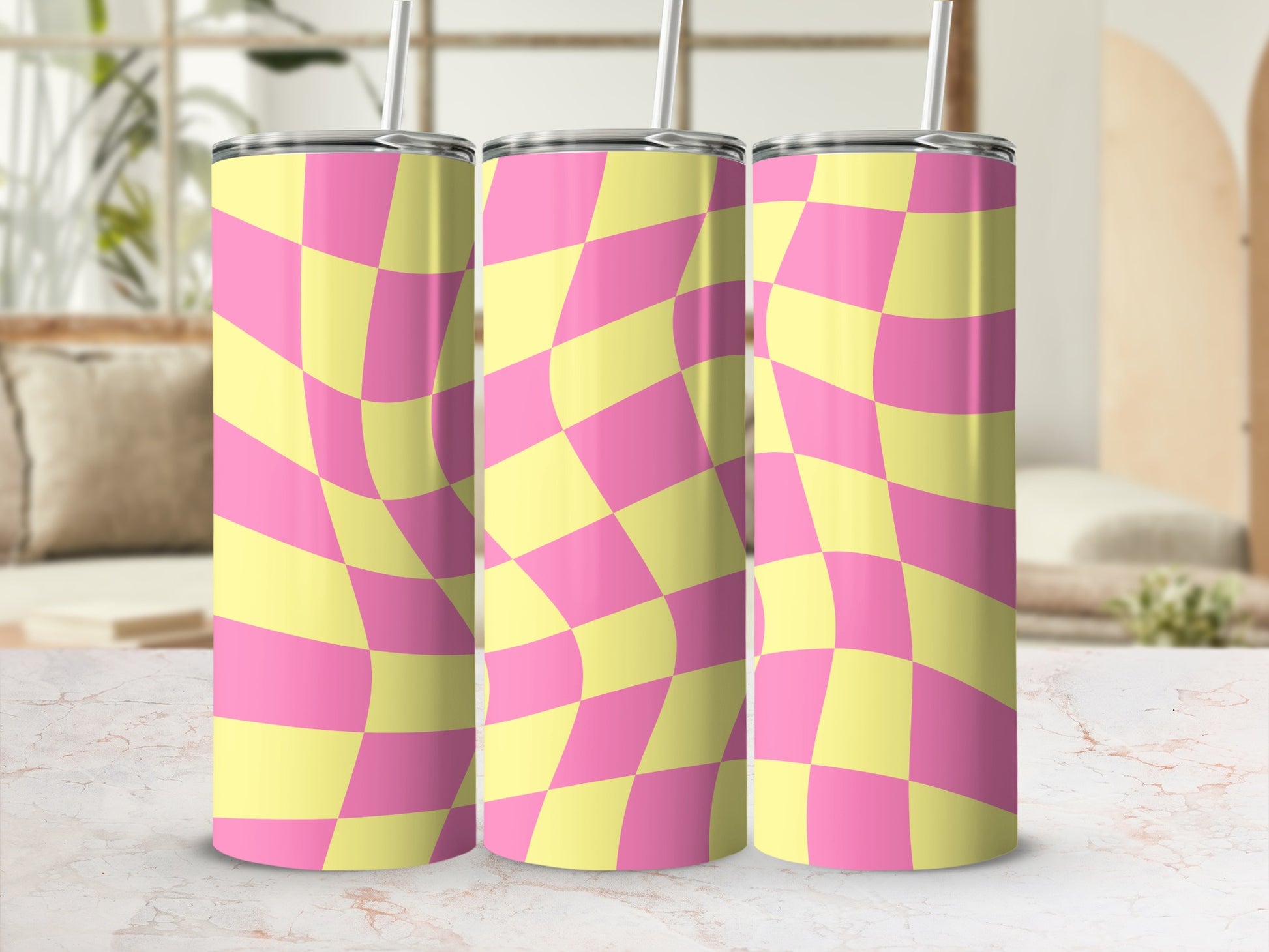 Pink and yellow checkered warped pattern tumbler with straw.