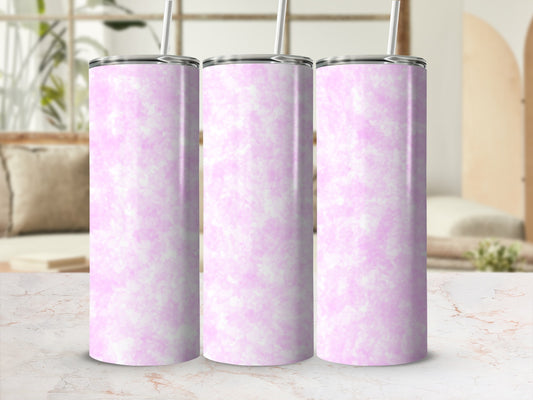 Three pink marbled tumblers with straws on a countertop.