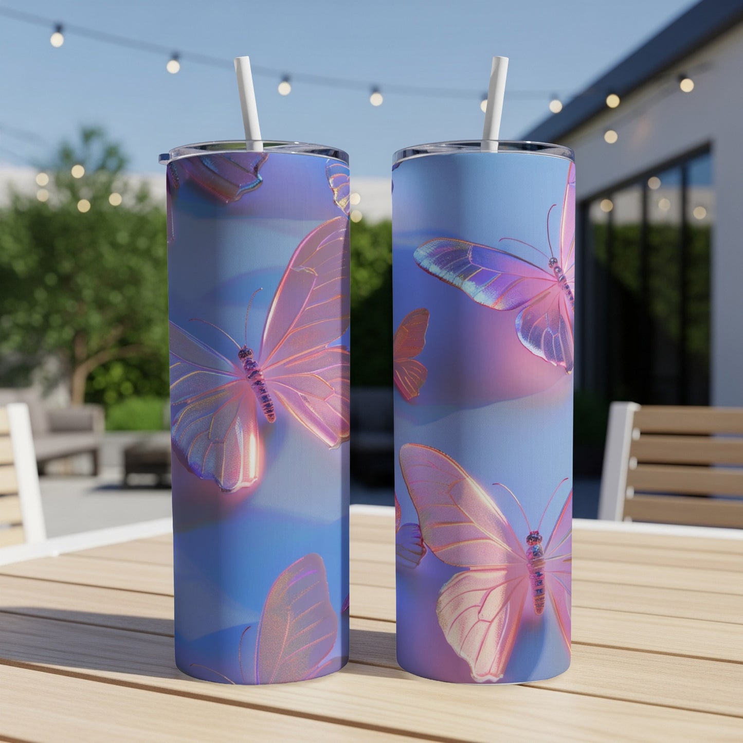 Two iridescent butterfly patterned tumblers with straws on a wooden table.