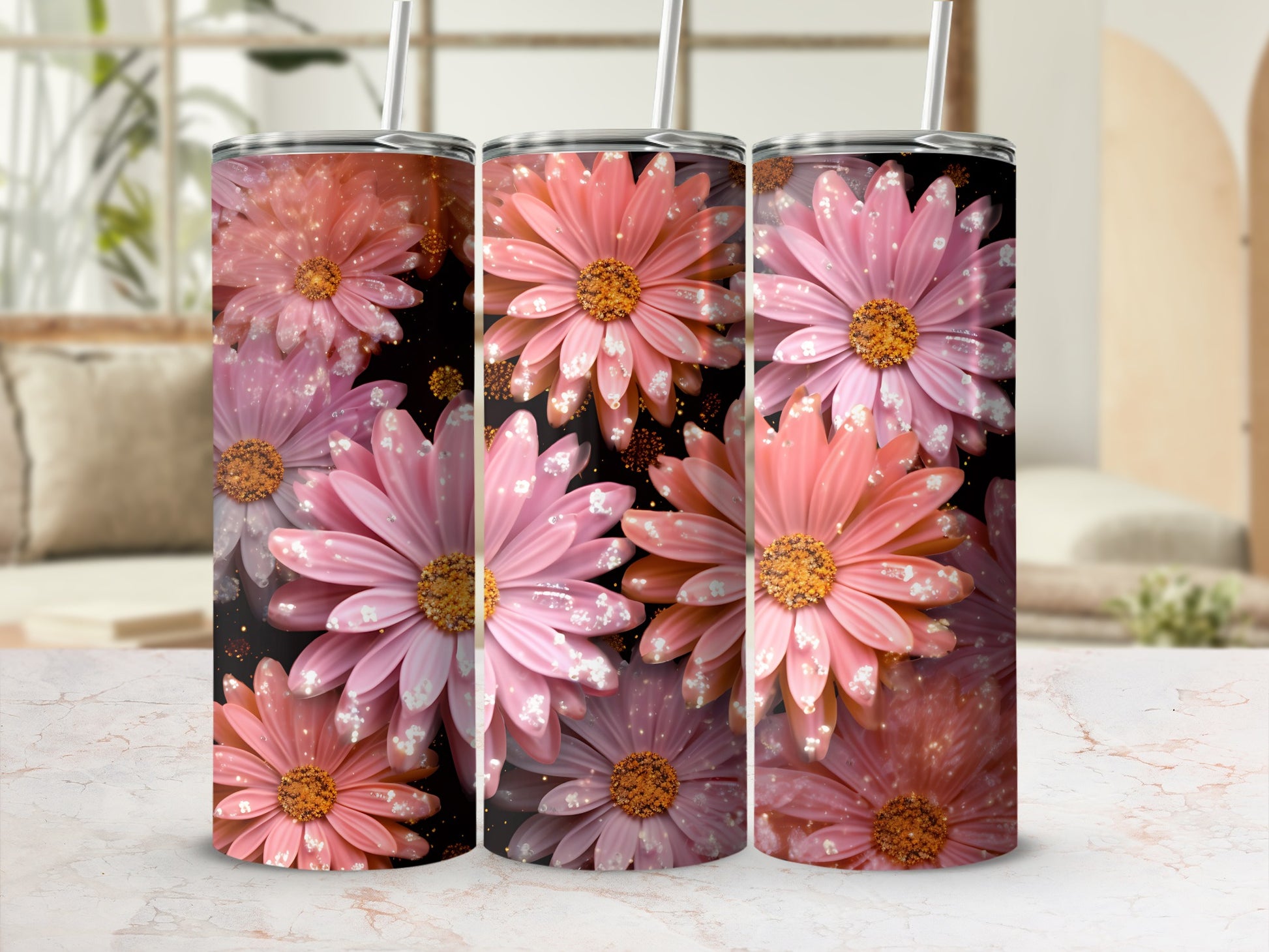 Three tumblers with pink and orange daisy floral design and glitter accents.