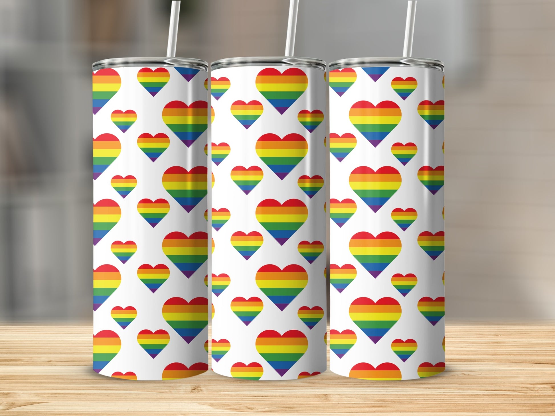 Three white tumblers with rainbow heart pattern.