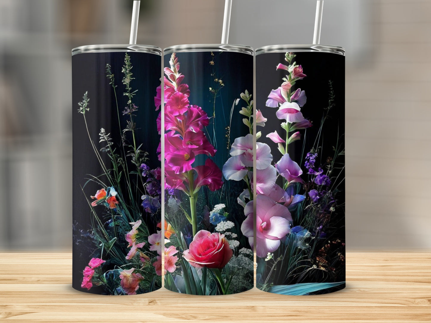 Three tumblers with a vibrant floral design against a dark background.